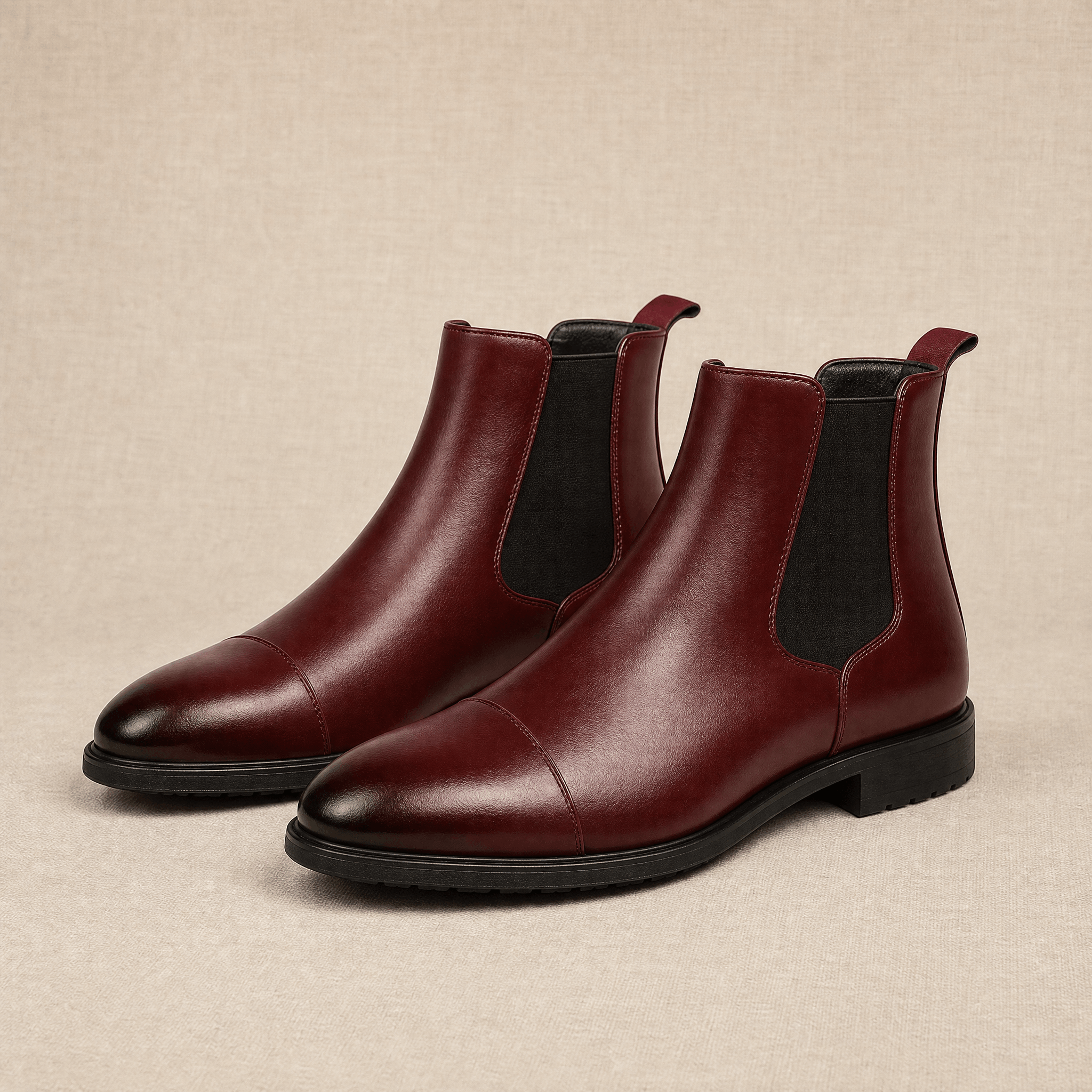 Burgundy vegan leather Chelsea boots with cap toe detailing, elastic side gussets and rear pull tabs.