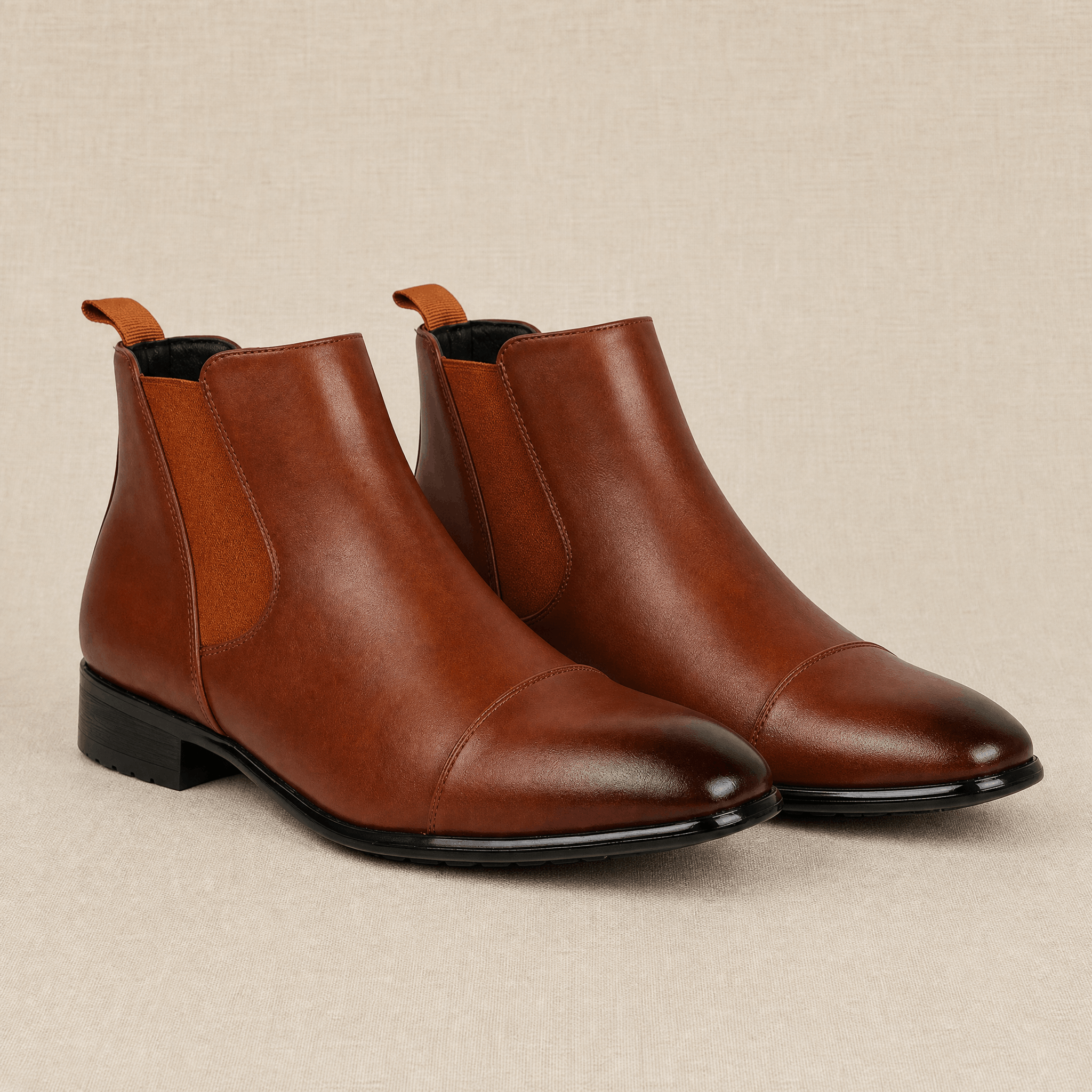 Brown vegan leather cap toe Chelsea boots with elastic side gussets, rear pull tabs and a rubber outsole.