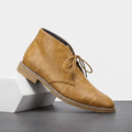 Light brown vegan leather lace-up chukka boot with three-eyelet lacing and a lug sole.