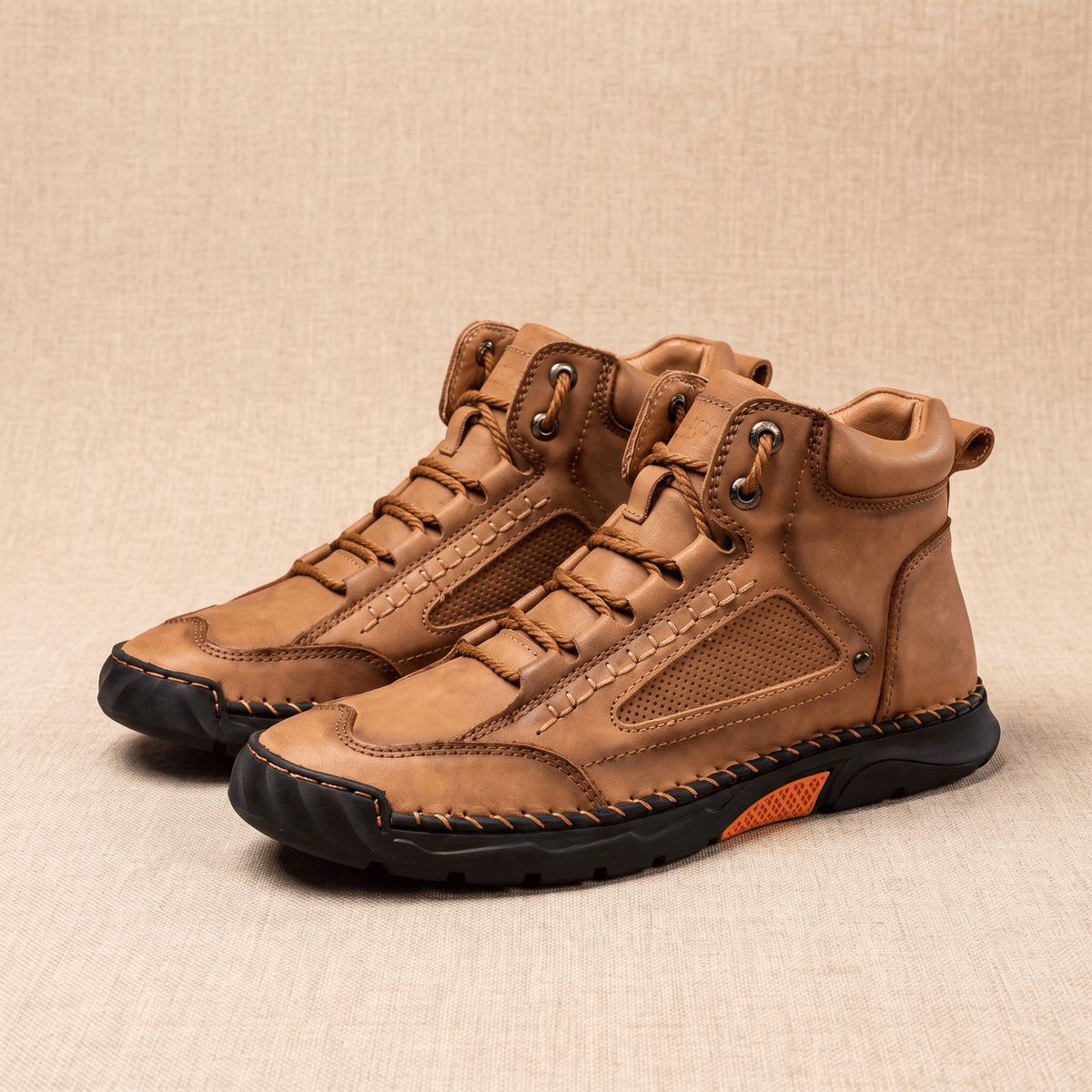 Tan vegan leather ankle hiking boots with a wide toe box, mesh side panels, and a rugged black lug outsole on a neutral background.