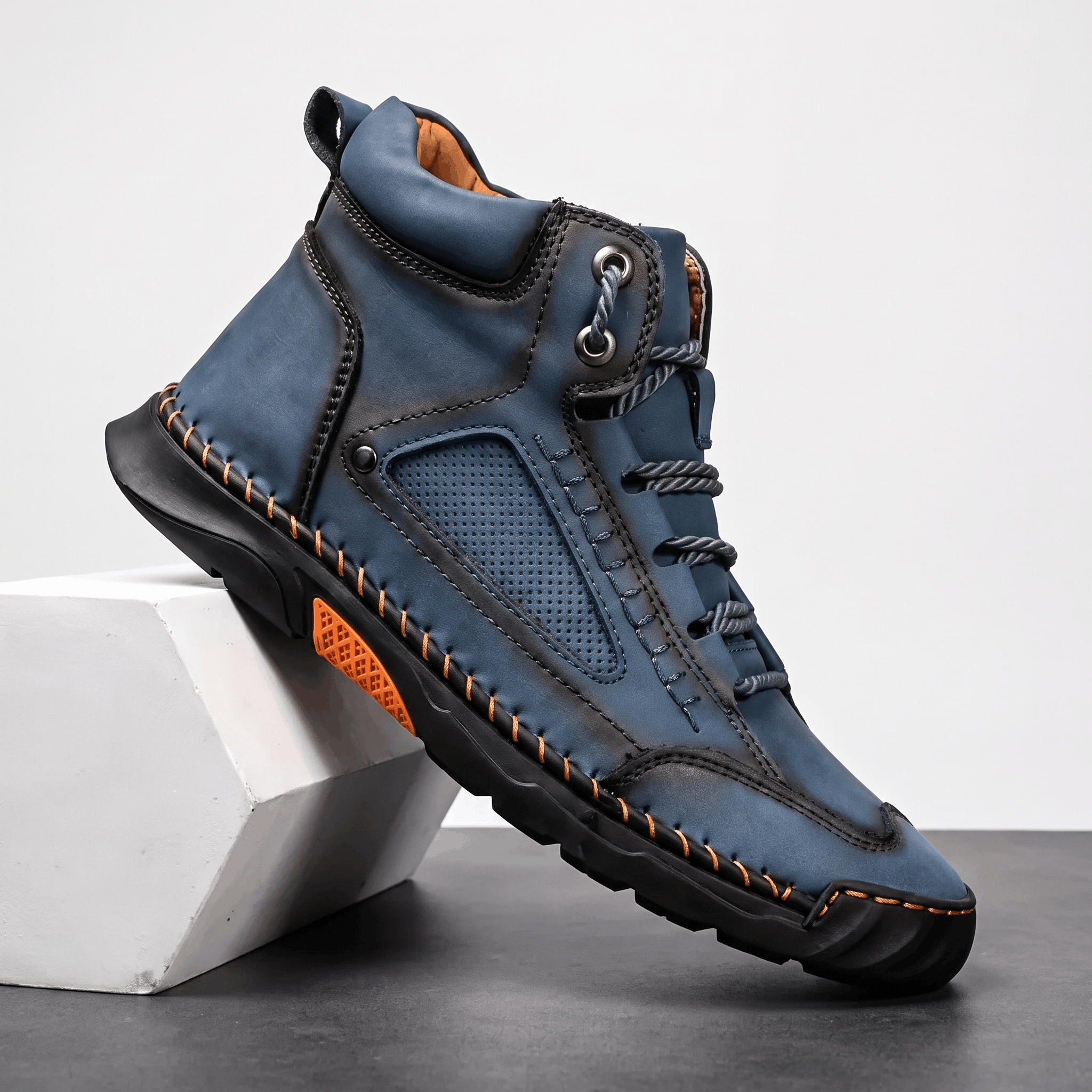 Blue vegan leather hiking boot with a wide toe box, perforated side panels, contrast stitching, and a rugged lug outsole.