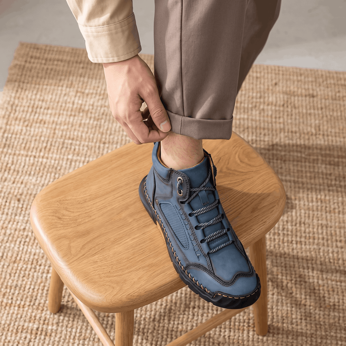 Blue vegan leather ankle hiking boots with a wide toe box, mesh side panels, and a thick, non-slip lug outsole on a wooden stool.
