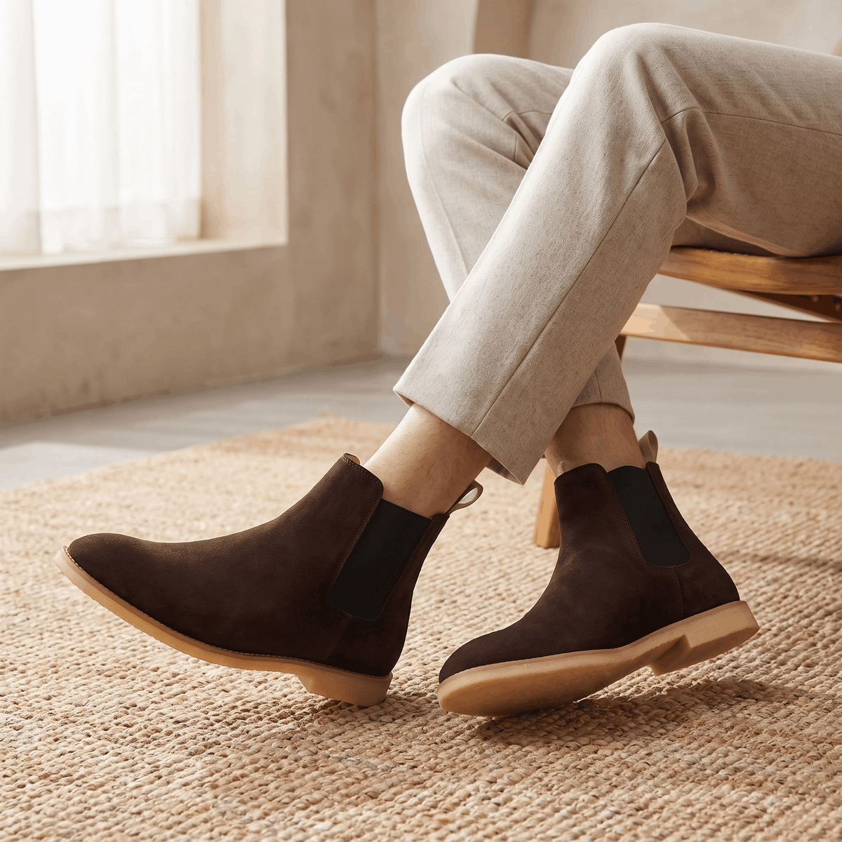 Person wearing dark brown vegan suede Chelsea boots with light trousers, showing the side profile and contrasting sole.