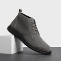Gray vegan suede lace-up chukka boots displayed on a white pedestal.