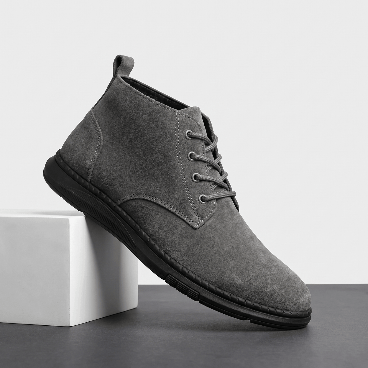 Gray vegan suede lace-up chukka boots displayed on a white pedestal.