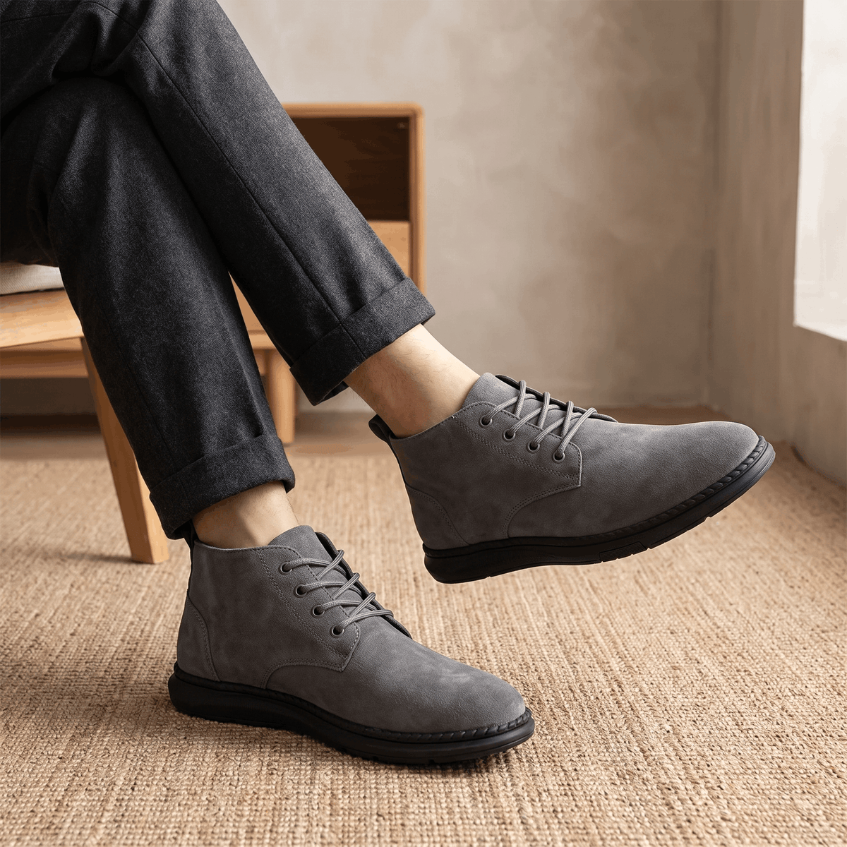 Gray vegan suede chukka boots worn with dark trousers and grey socks.