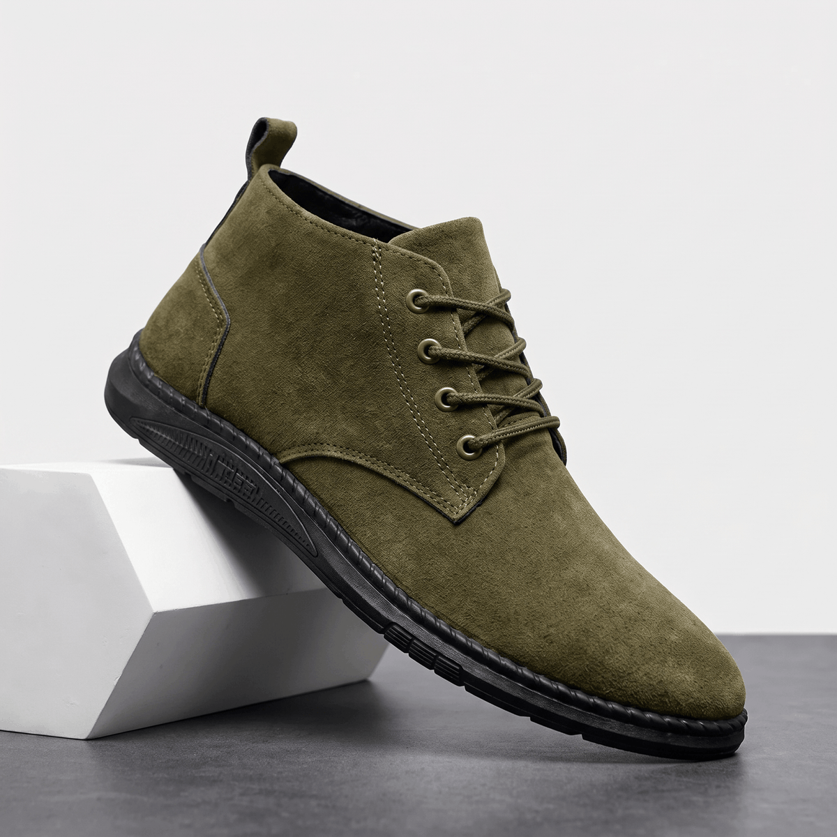 Olive green vegan suede lace-up chukka boot displayed on a white pedestal.