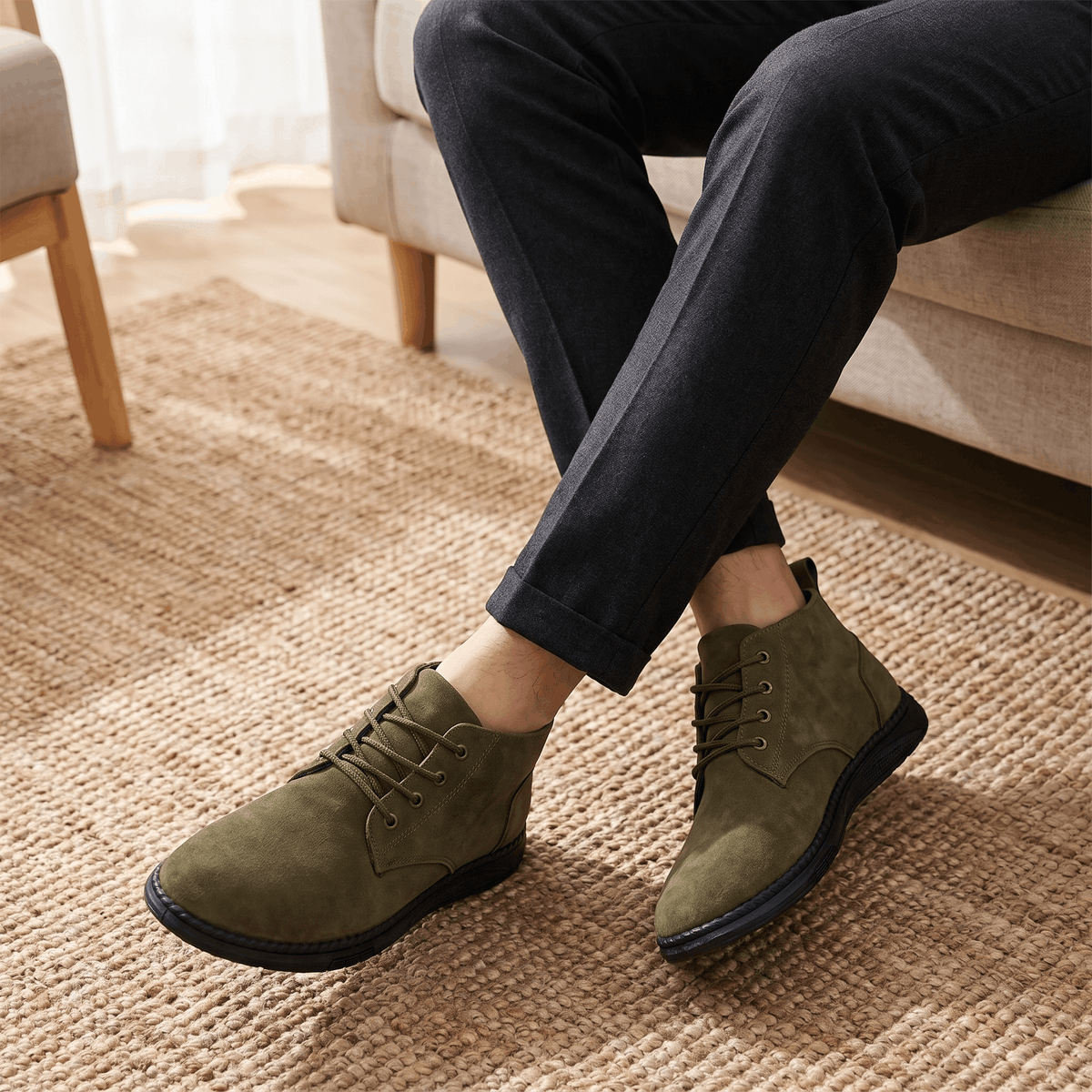 Olive green vegan suede chukka boots worn with black trousers.