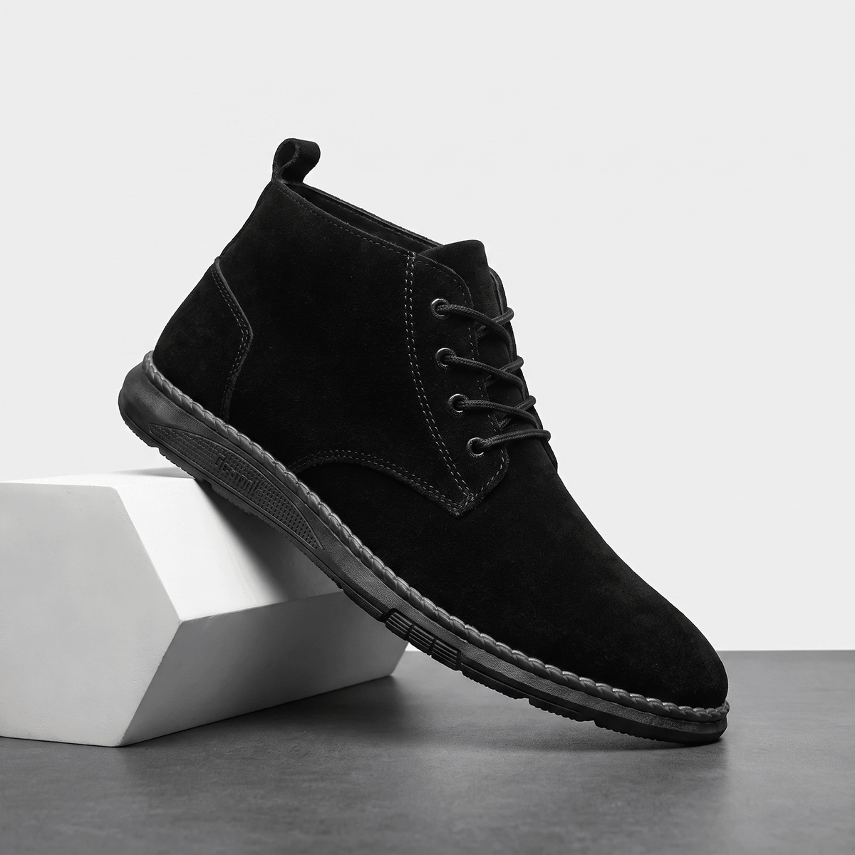 Black vegan suede lace-up chukka boot displayed on a white pedestal.