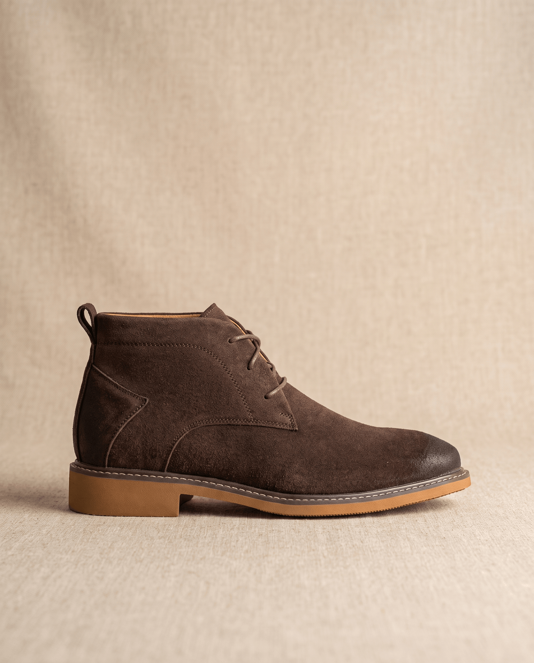 Dark brown vegan suede chukka boots with a three-eyelet lace-up design and a flat welted rubber outsole.