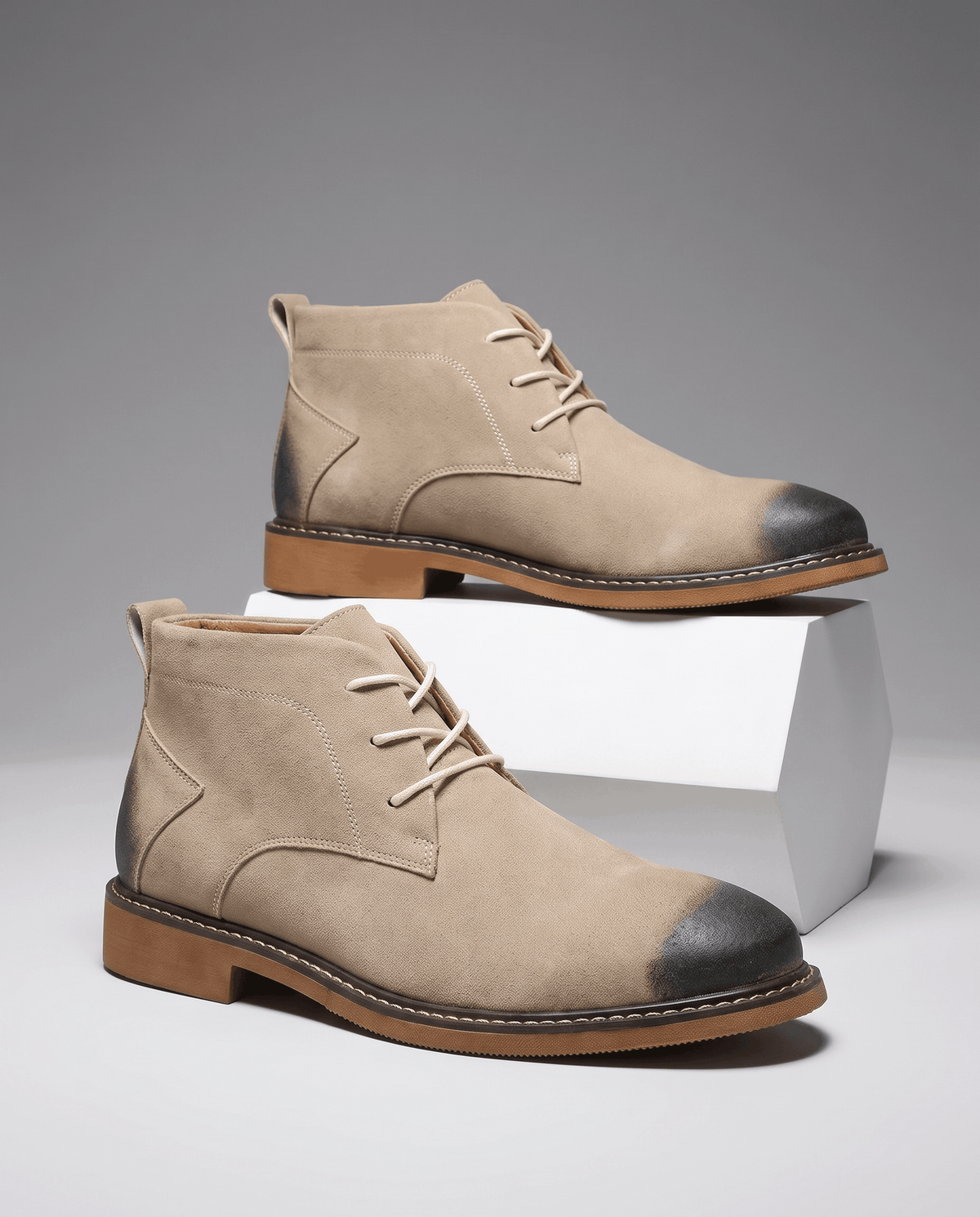 Beige vegan suede chukka boots with three-eyelet lacing, burnished toe caps, and a welted rubber outsole.