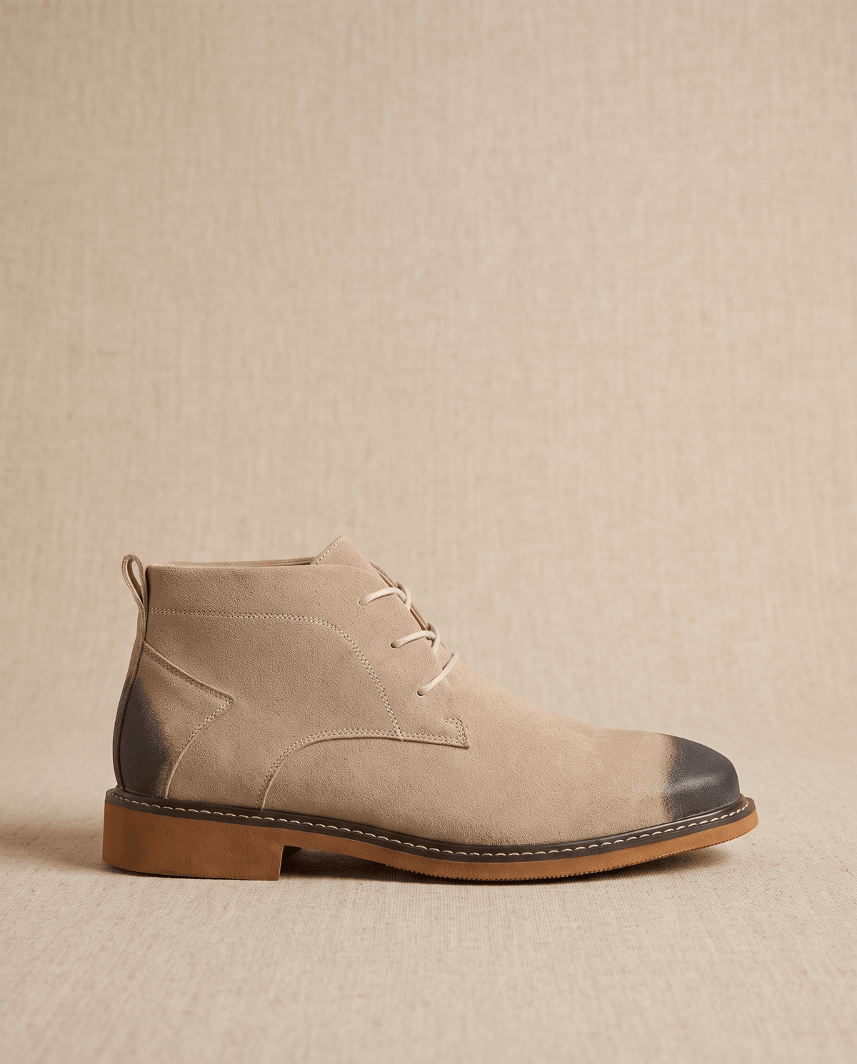 Beige vegan suede chukka boots with a three-eyelet lace-up throat, stitched welt, and flat rubber outsole.