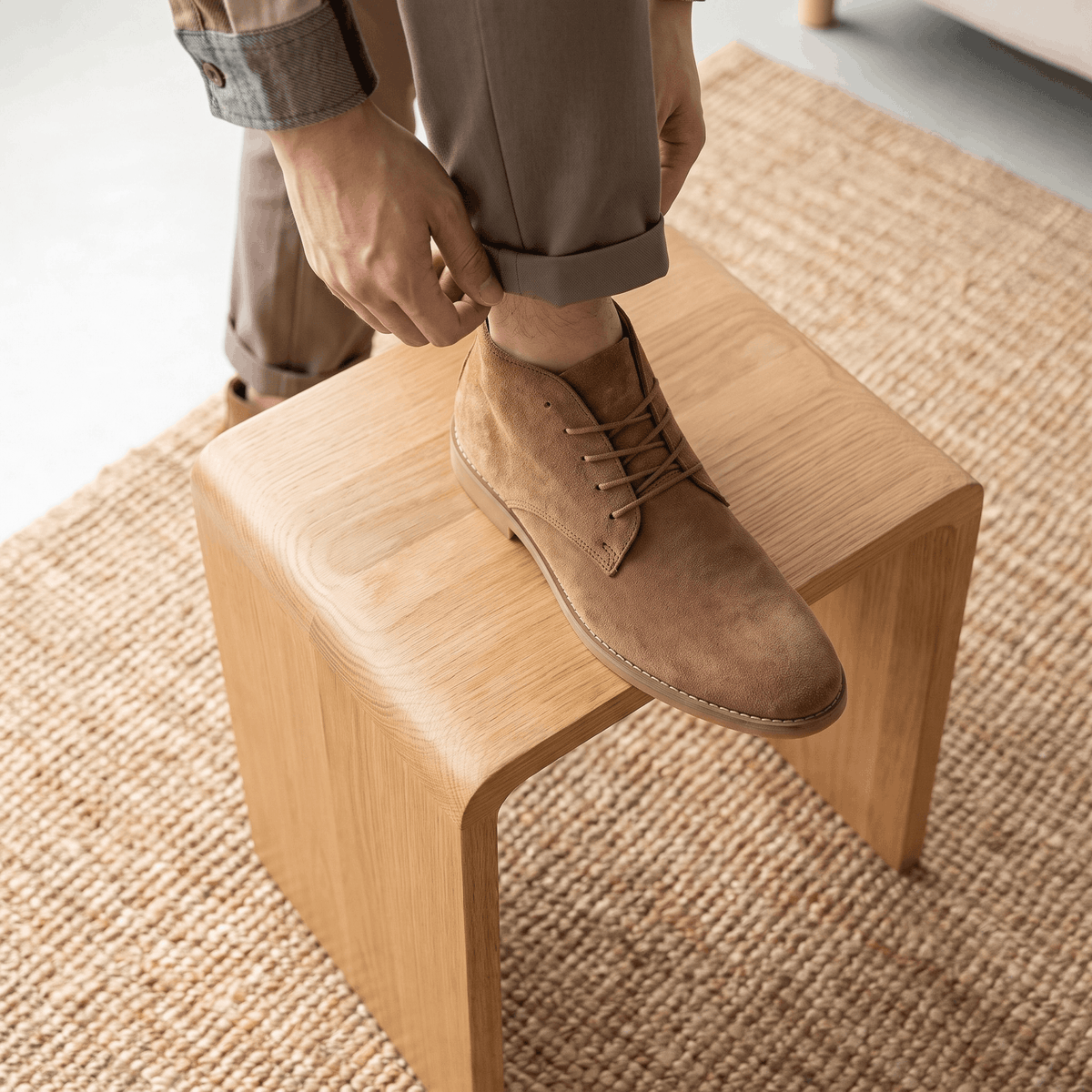 Brown vegan suede desert boot being put on while seated.