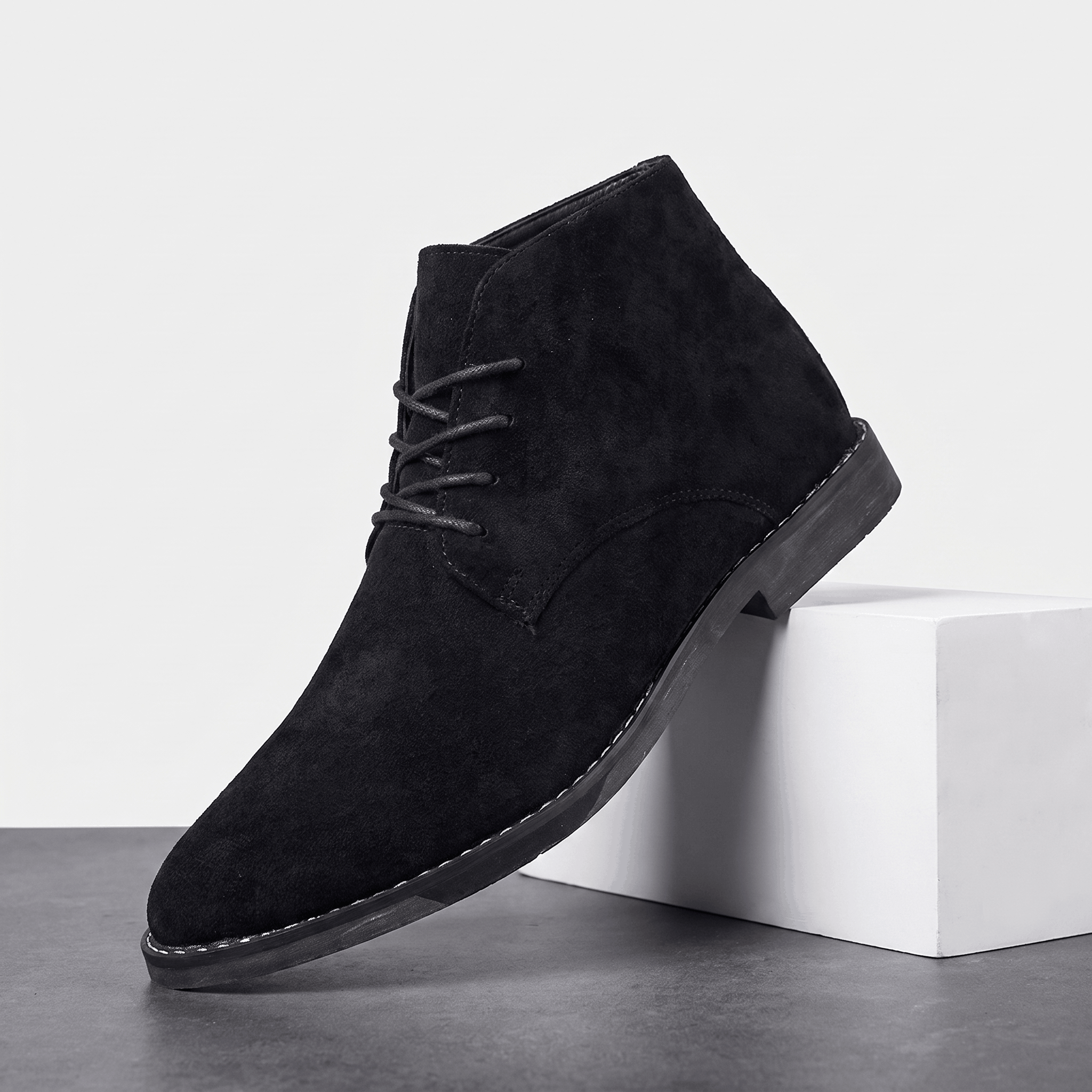 Black vegan suede lace-up desert boot displayed on a white pedestal.