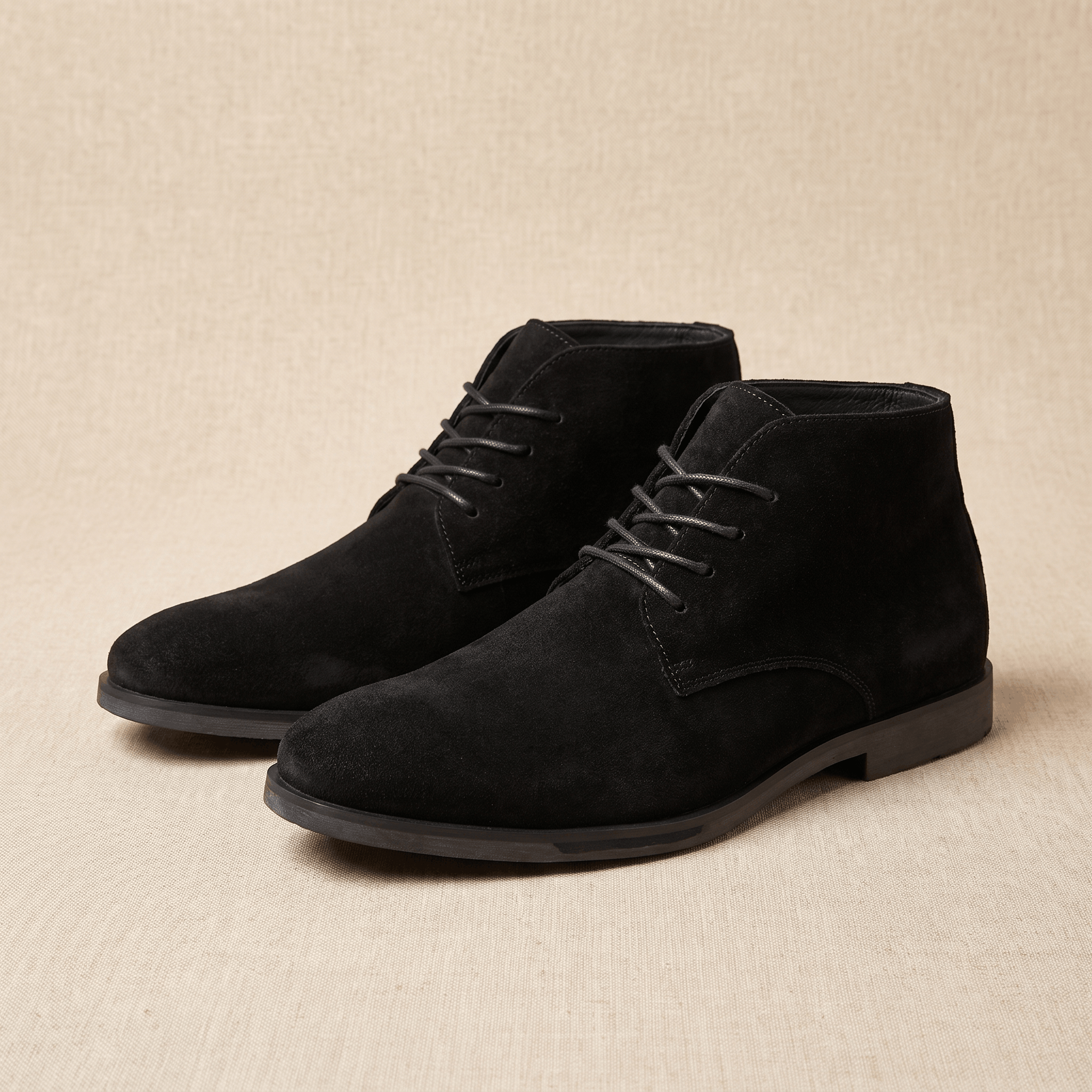 Pair of black vegan suede lace-up desert boots displayed on a neutral background.