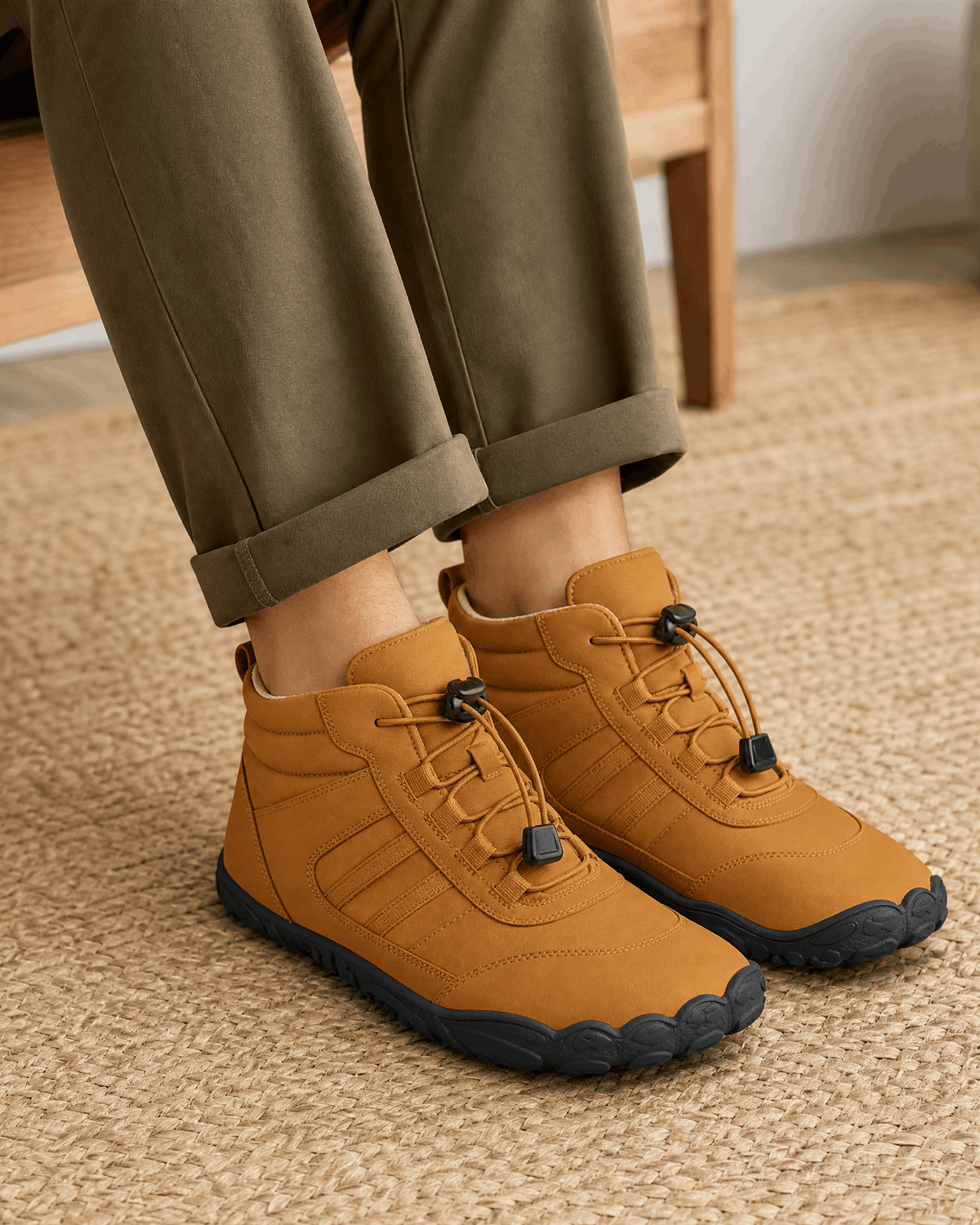 Brown water-repellent winter ankle boots with bungee laces, a fleece-lined collar, and a flexible black rubber sole.