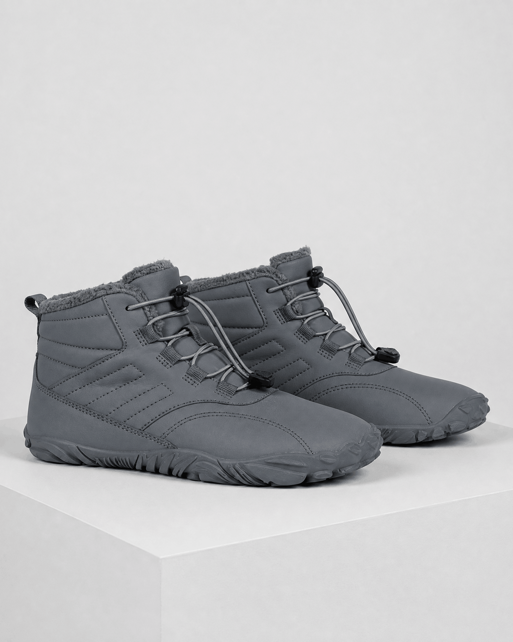 Gray water-repellent winter ankle boots with a fleece-lined collar, flexible rubber sole, and bungee lace toggle system.