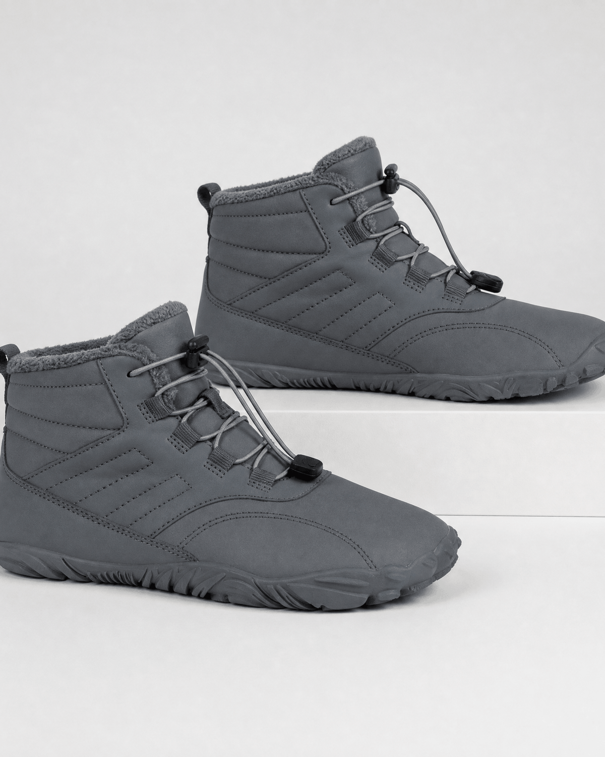 Gray water-repellent winter ankle boots with fleece-lined collars, flexible rubber soles, and bungee lace toggles.
