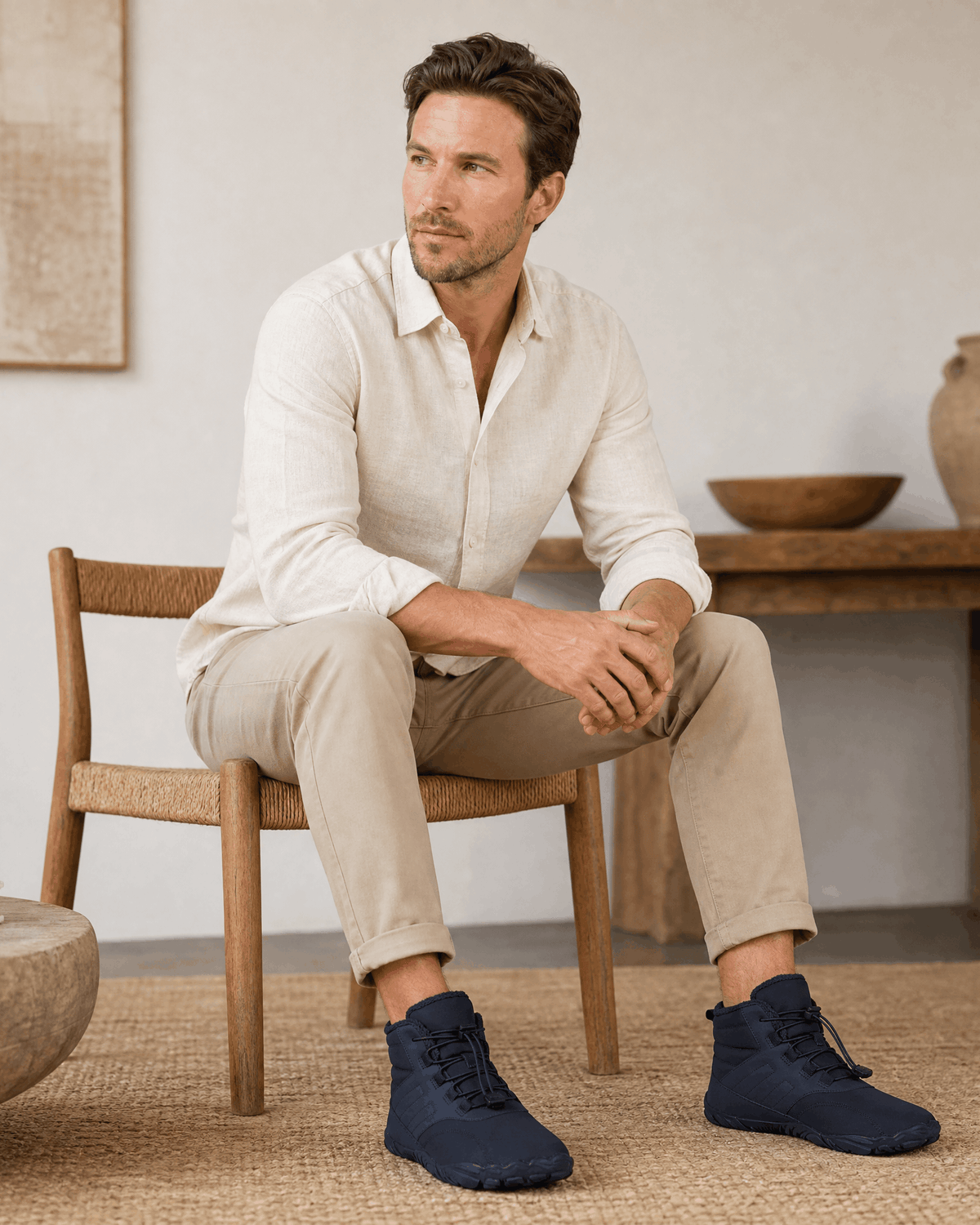 Blue water-repellent winter ankle boots with a flexible rubber sole, bungee laces, and fleece-lined collar worn by a man.