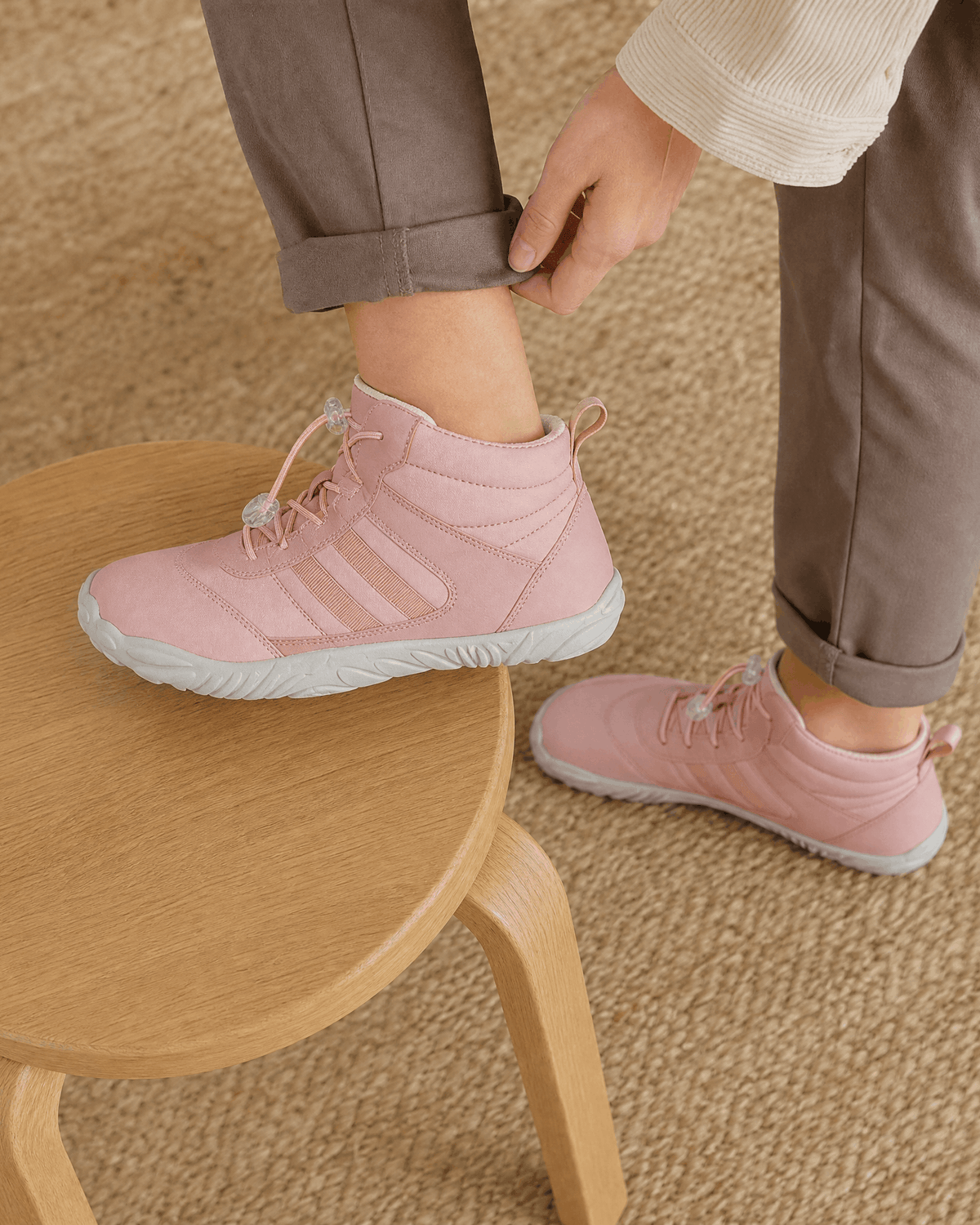 Pink water-repellent winter ankle boots with bungee lace toggles, flexible rubber soles, and a reinforced toe cap.