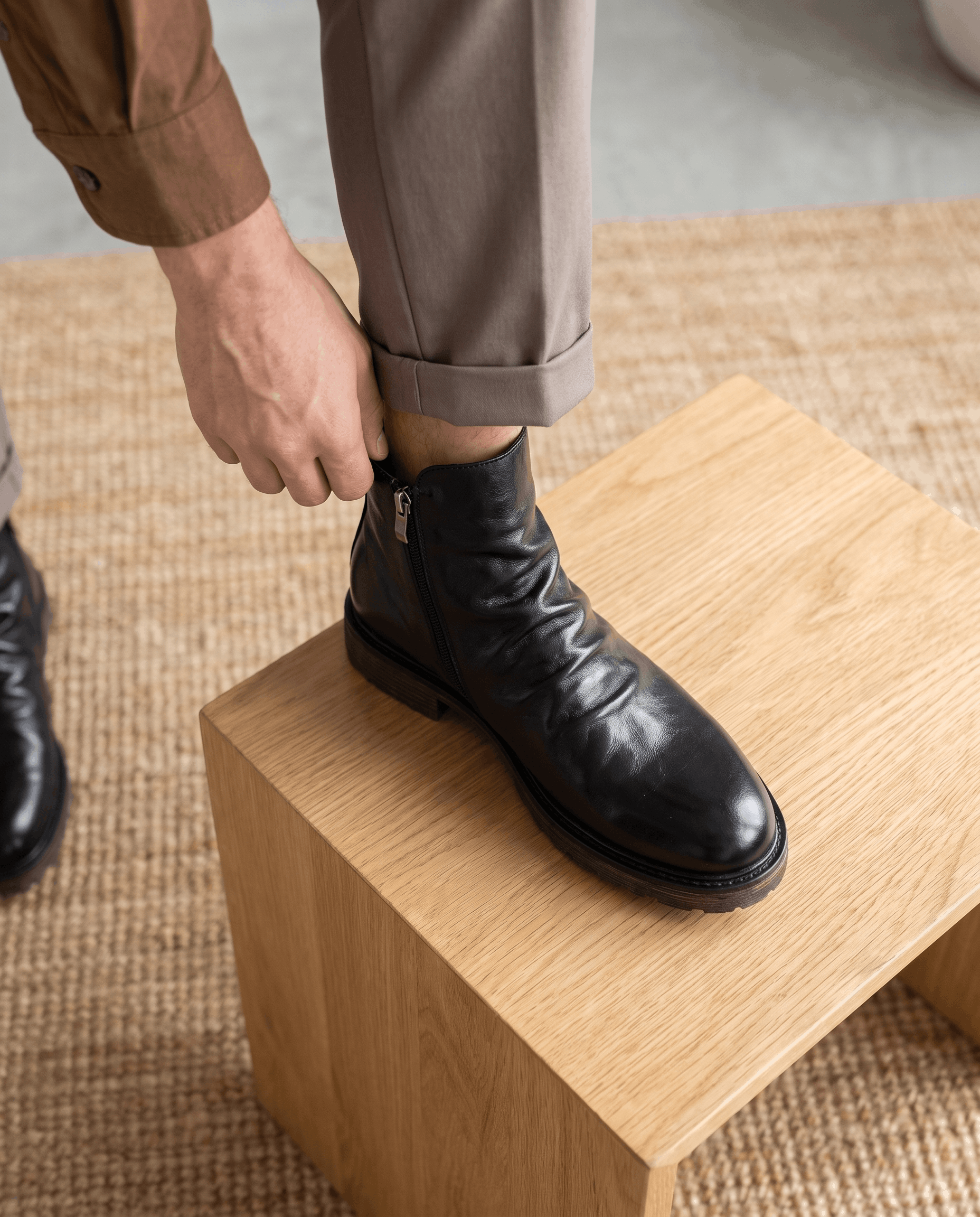 Black waxed leather ankle boots with a ruched shaft, side zip closure, and a durable cushioned rubber outsole.