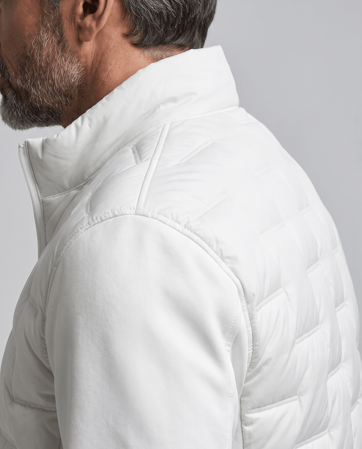 Close-up of the quilted panel and fleece sleeve on a white puffer jacket