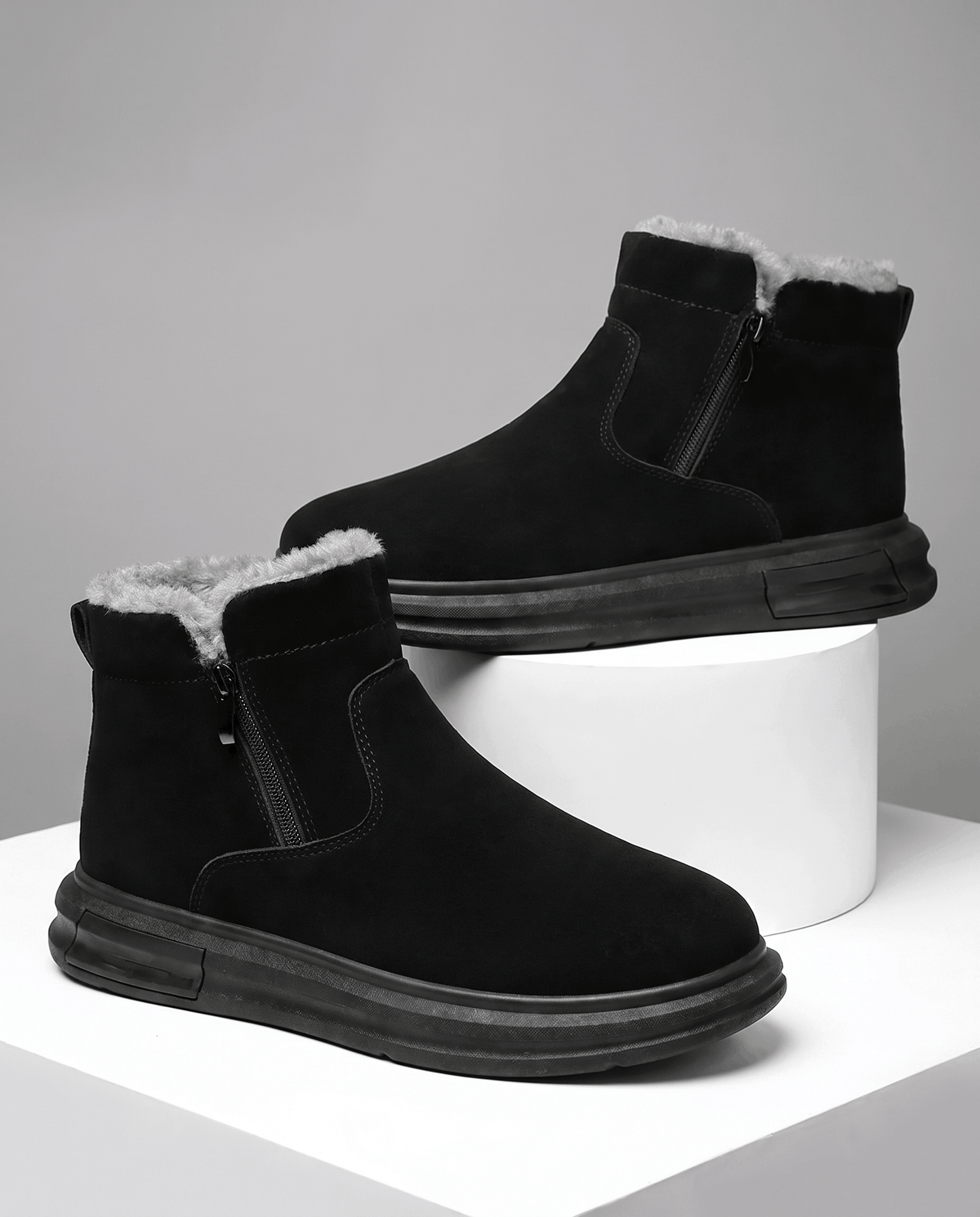 Black wide toe box winter boots for men with side zip and plush fleece lining displayed on white blocks.