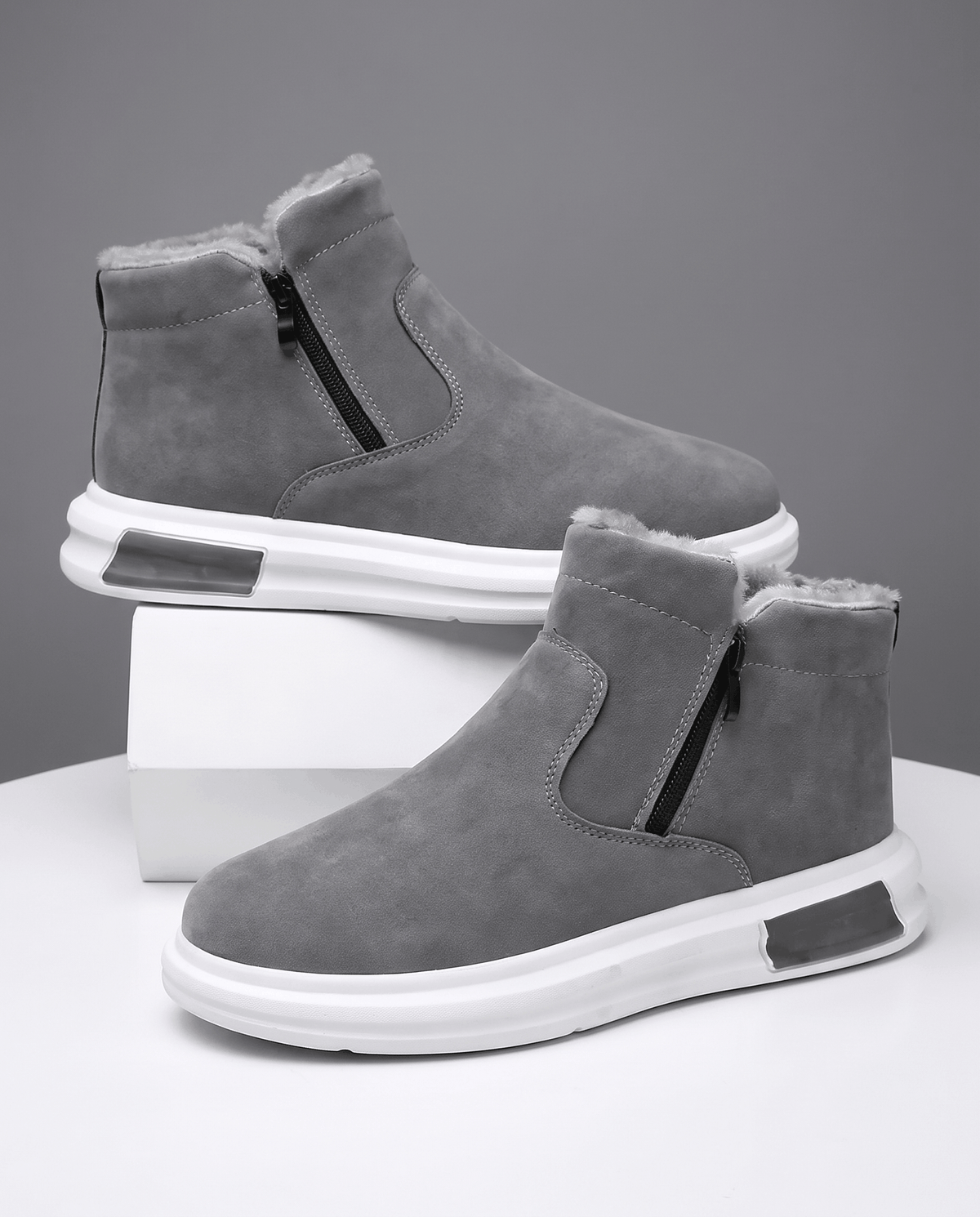 Gray fleece-lined winter boots with a wide toe box and side zip displayed on white blocks.