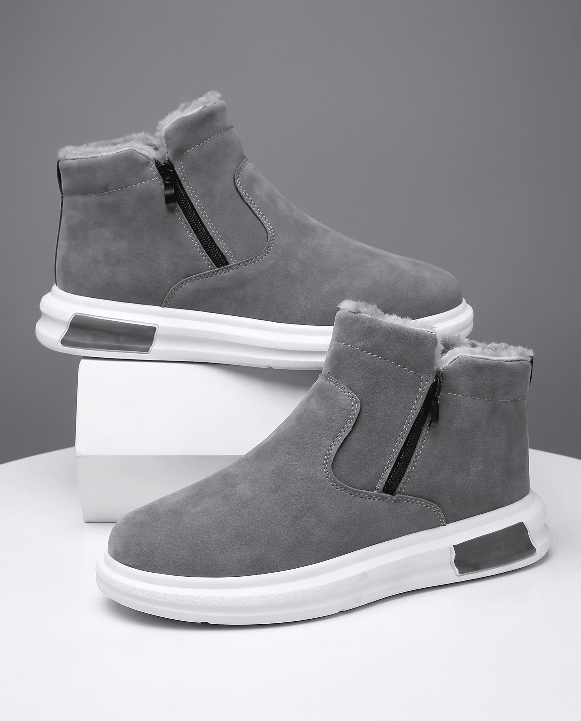 Gray fleece-lined winter boots with a wide toe box and side zip displayed on white blocks.