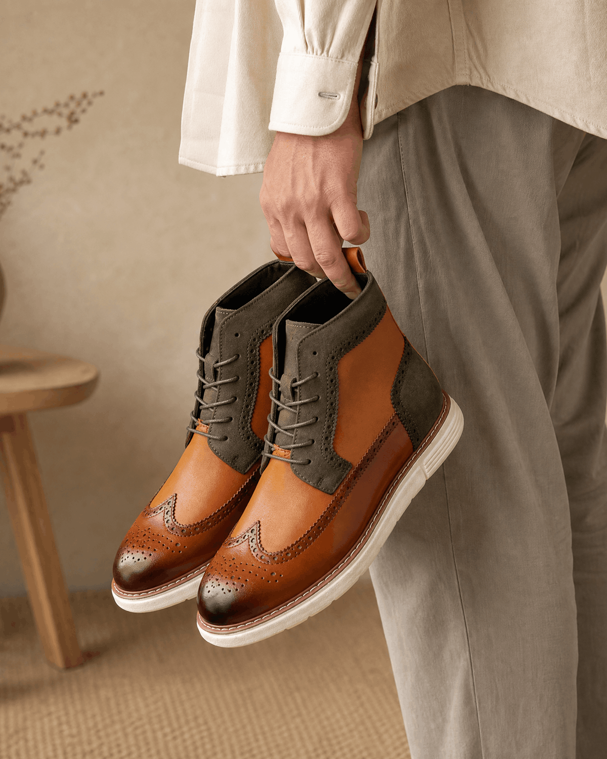 Smooth grain brown leather wingtip boots with olive matte panels, brogue perforations, and a chunky white cupsole.
