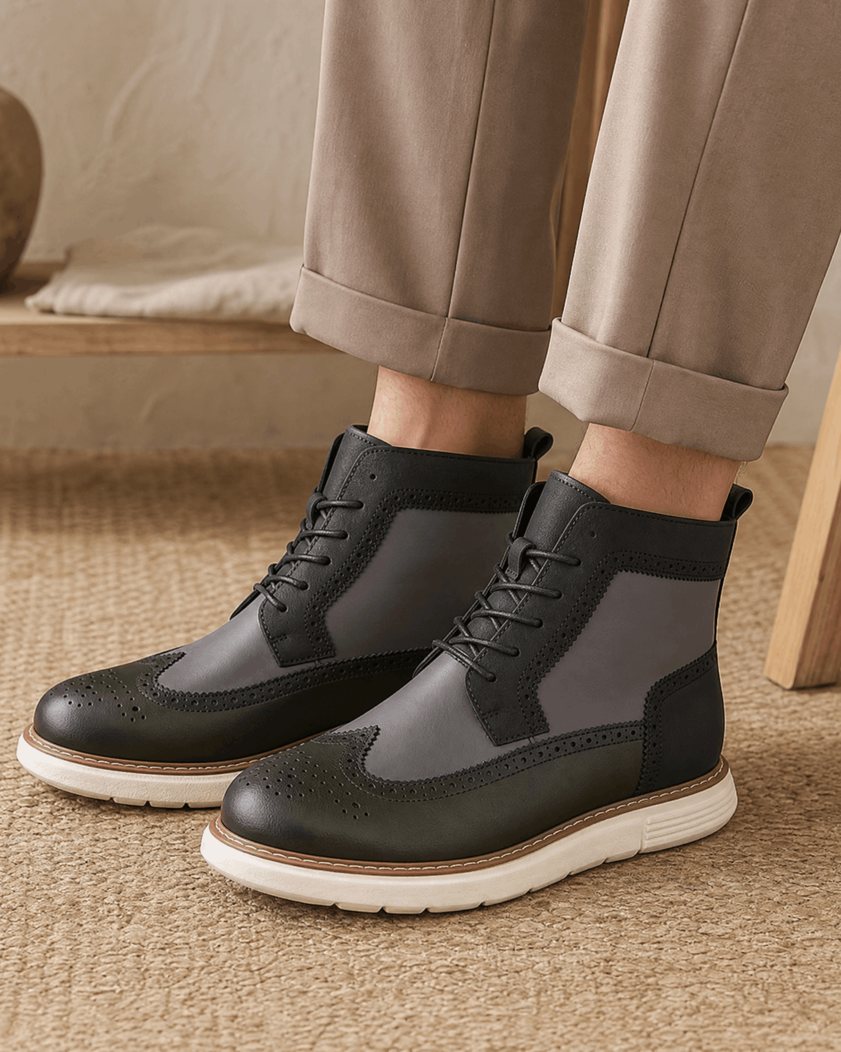 Gray wingtip boots with brogue perforations, lace-up front, and a chunky white cupsole on a textured floor.