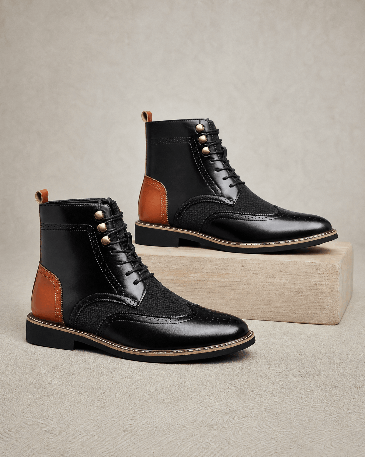 Black smooth grain leather ankle boots with wingtip brogue detailing, woven-texture panels, and metal eyelet lacing.