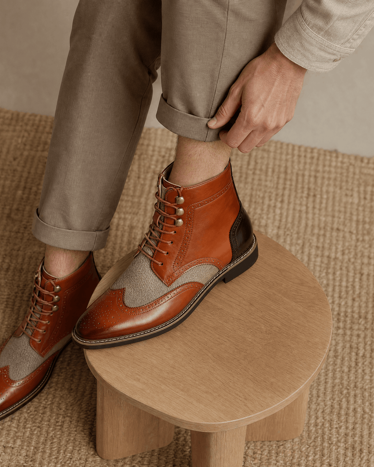 Smooth grain leather ankle boots in tan with wingtip brogue details, woven-texture panels, and metal eyelet lacing.