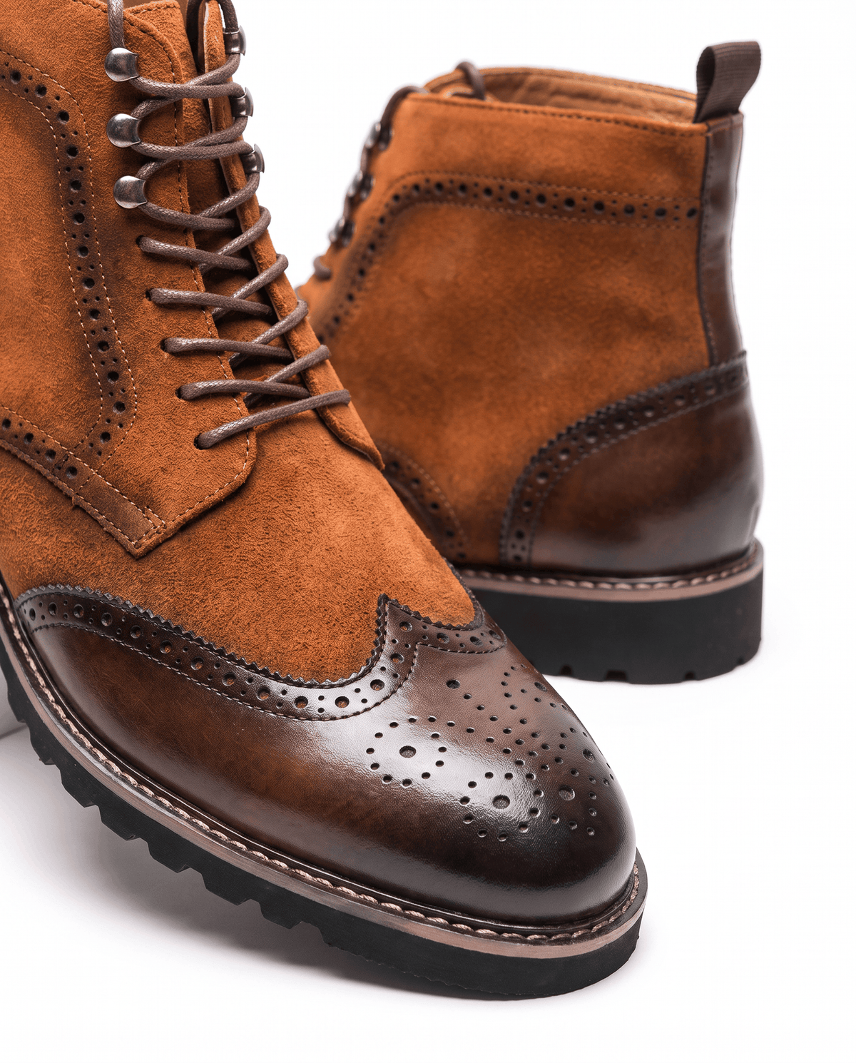 Close-up of dark brown brogue toe cap on a cognac suede ankle boot