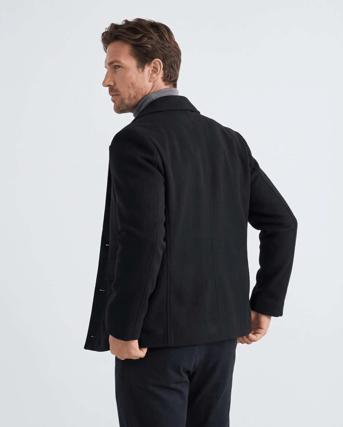 Model turned away in the black coat, shoulder and sleeve line in frame