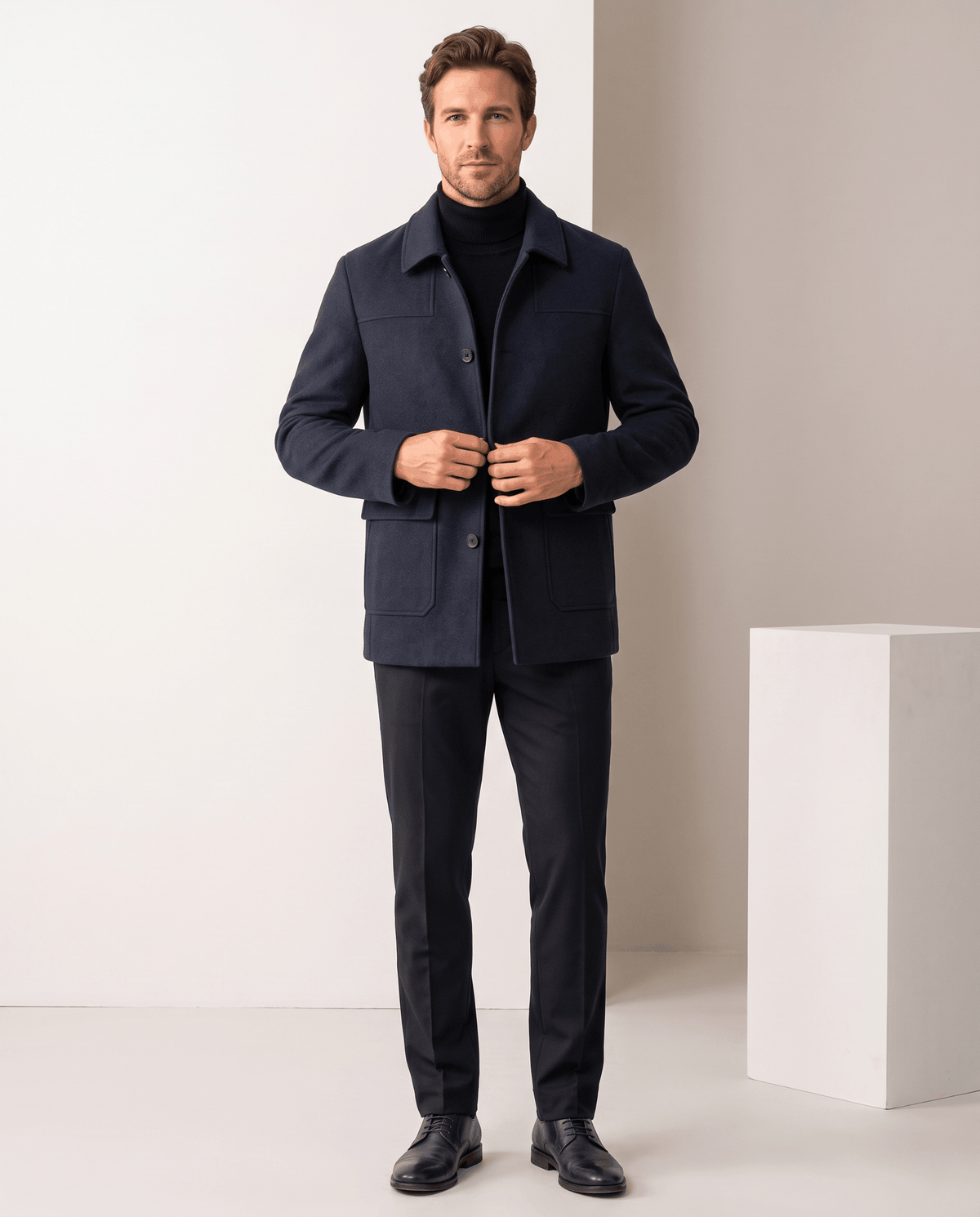 Full-length shot of the navy coat buttoned, worn with dark trousers