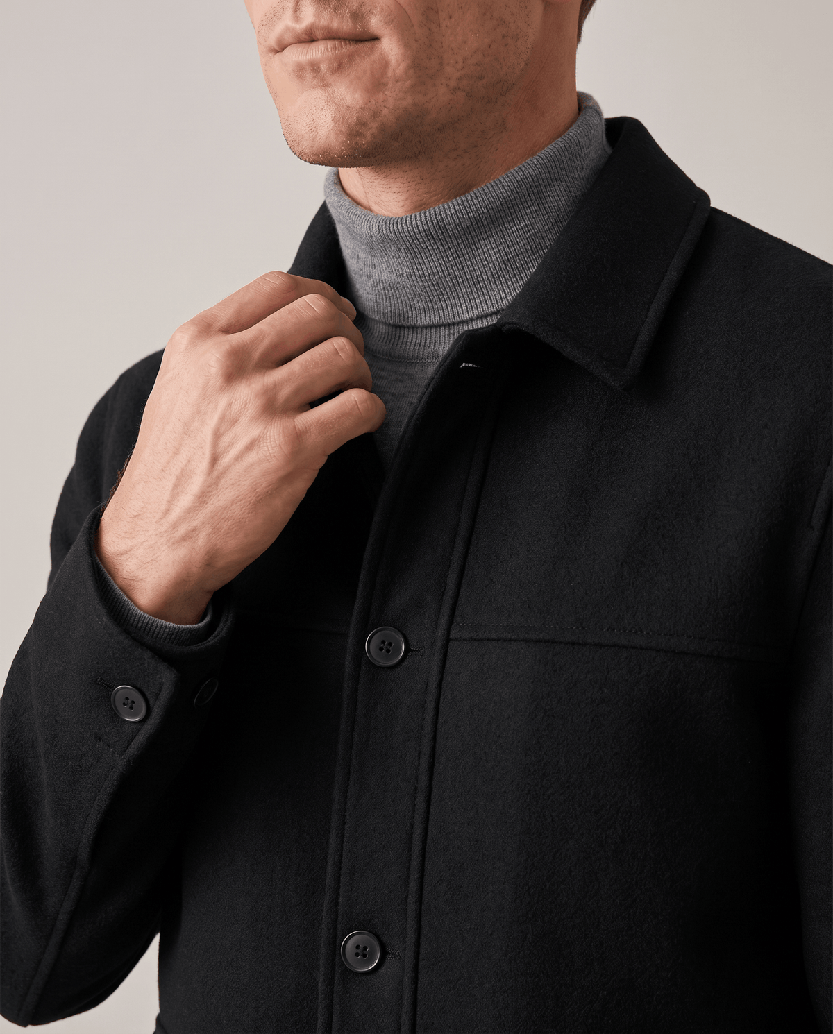 Black jacket collar detail worn open with the cuff tab buttoned at the wrist