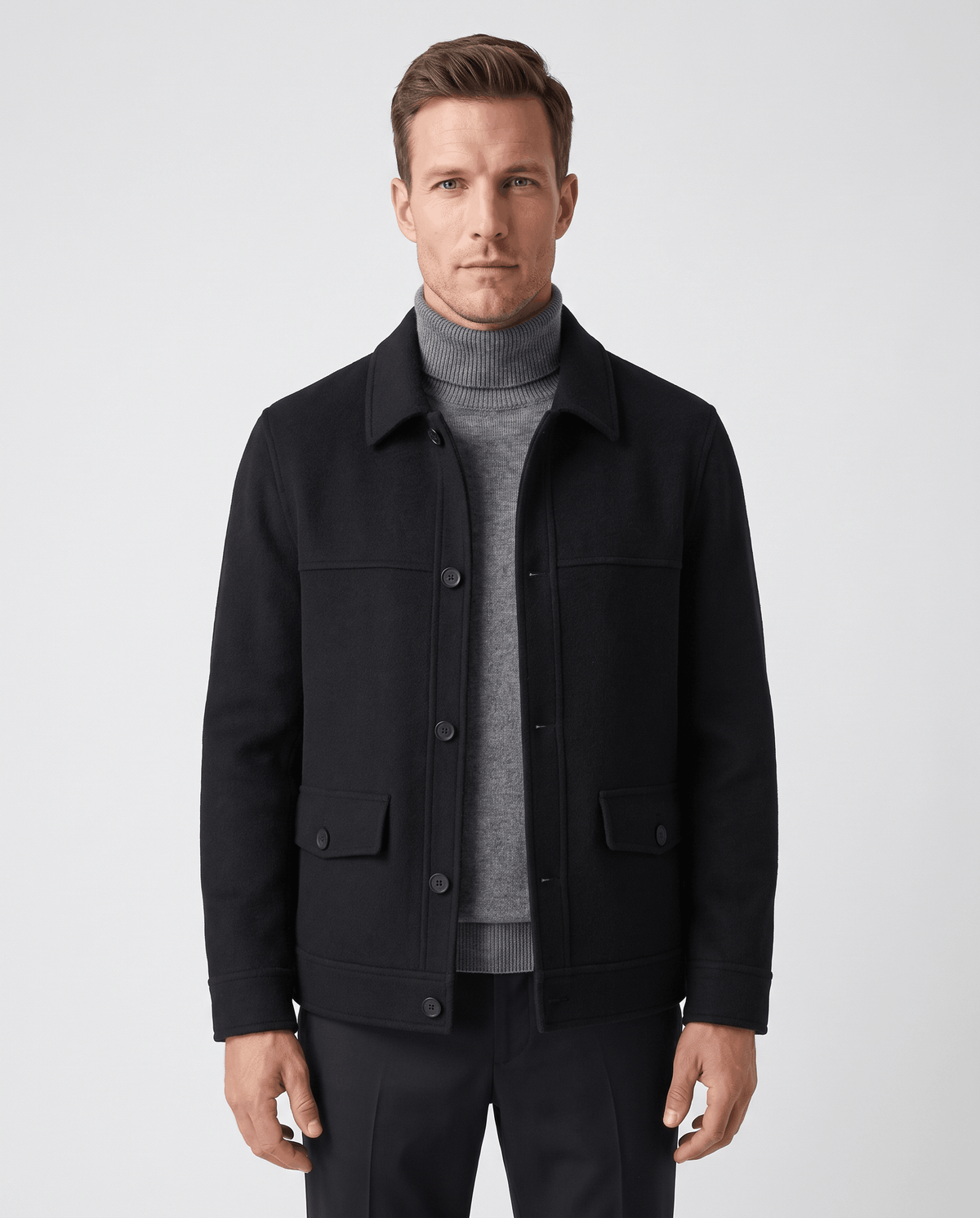 Black chore jacket front view buttoned over a gray turtleneck and dark trousers