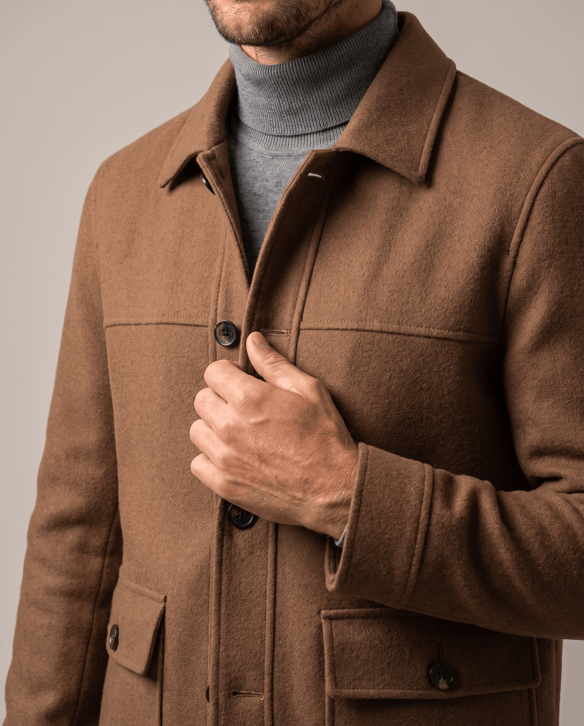Camel jacket collar detail with the point collar worn open over a gray turtleneck