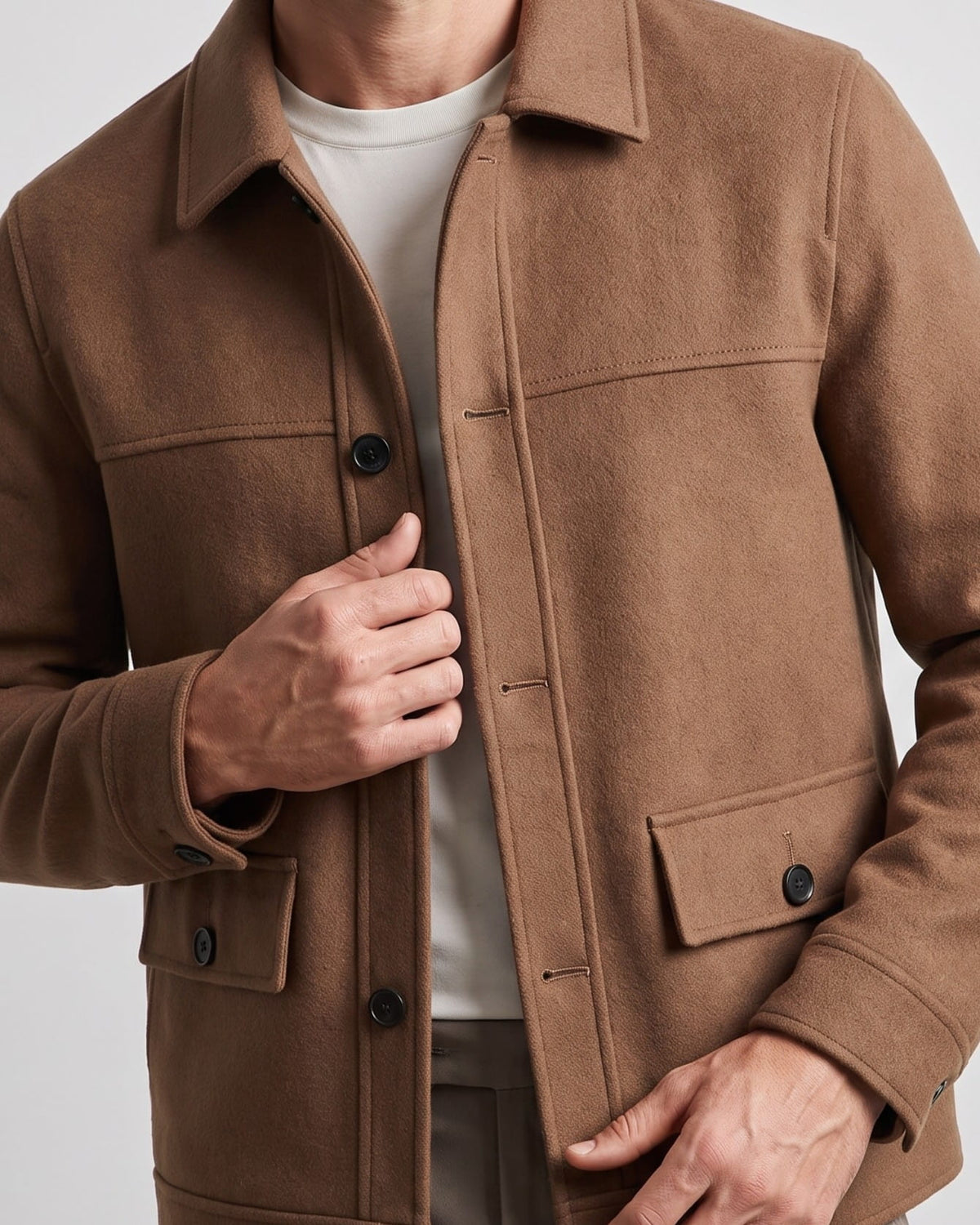 Close-up of a camel jacket placket with tonal buttons and bound double-faced edge