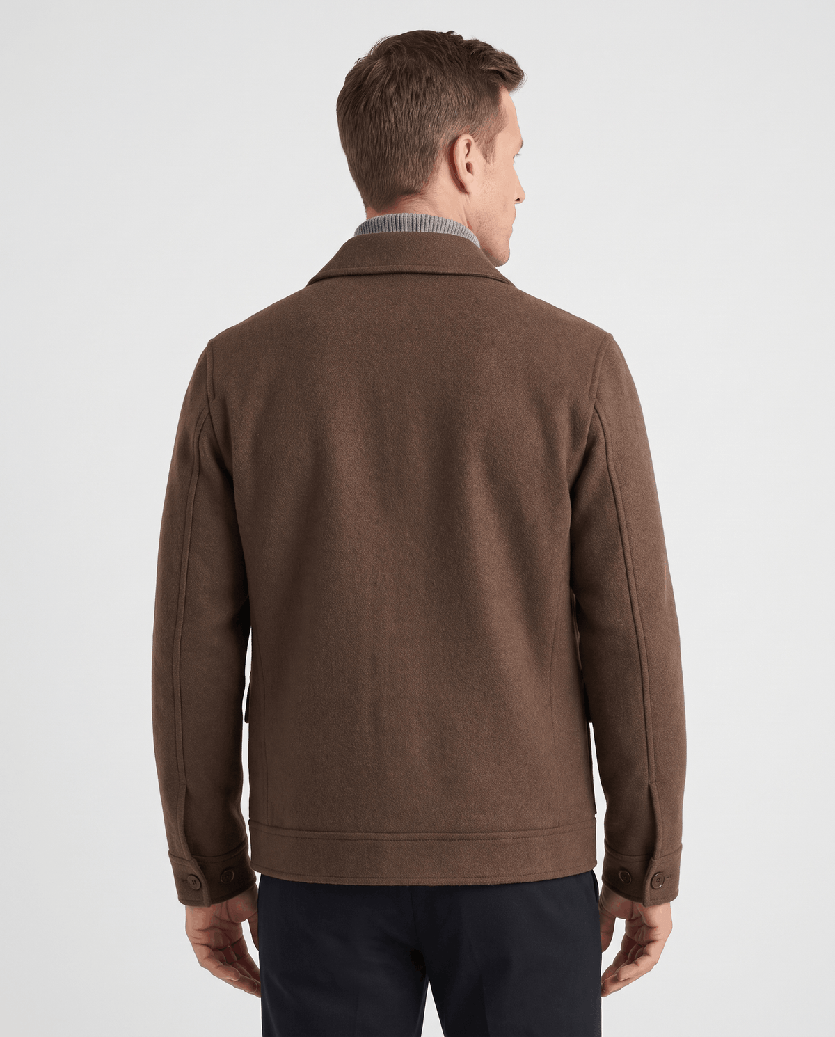 Back view of a dark brown jacket showing the center seam and buttoned hem tabs