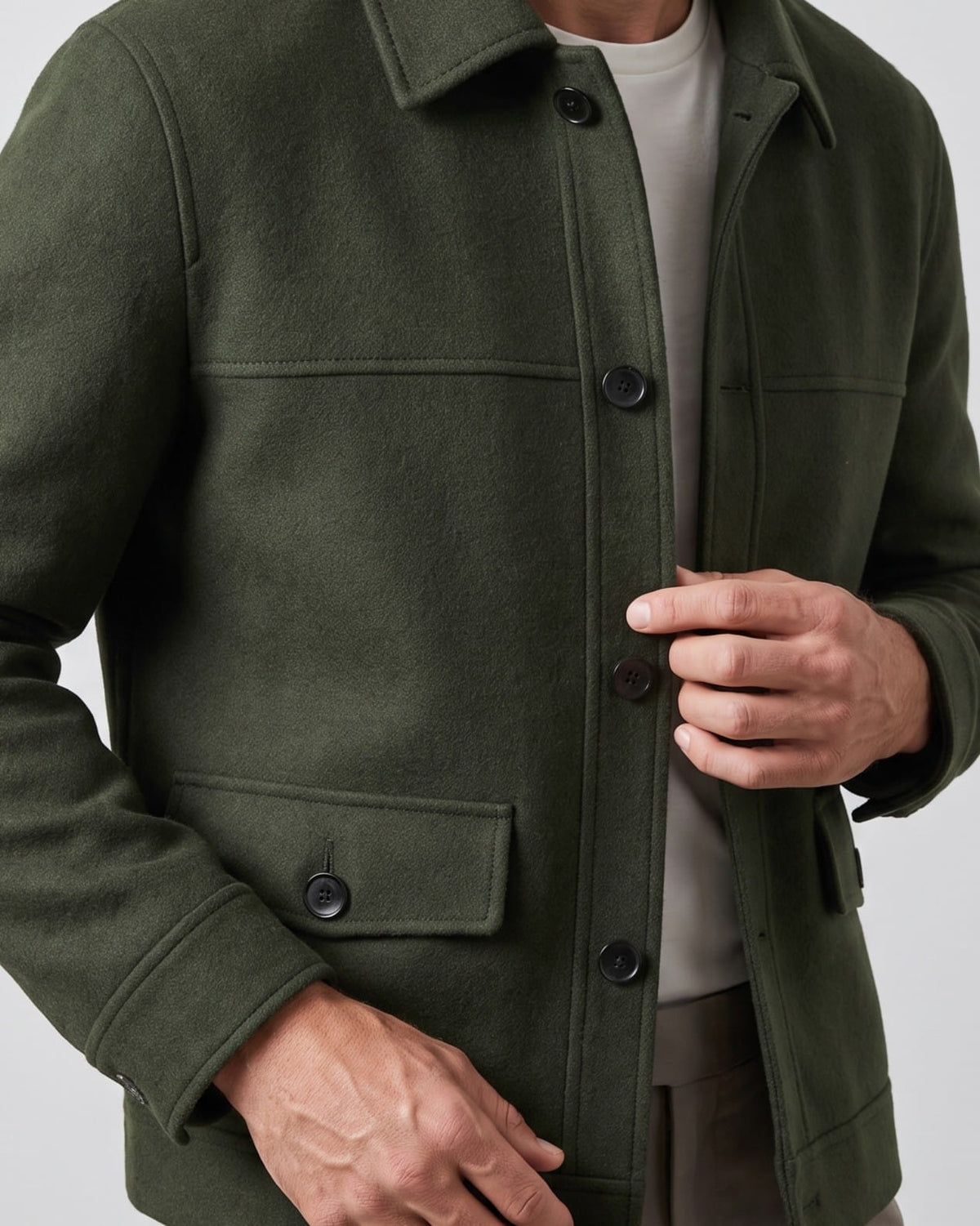 Olive green jacket chest detail with buttoned placket and flap pocket close up