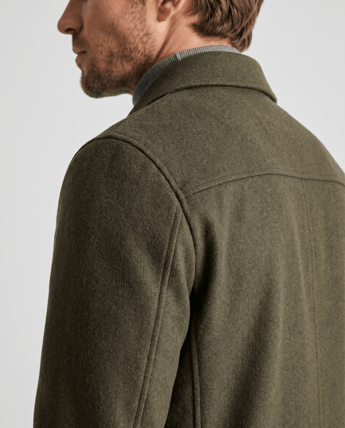 Shoulder and yoke seam detail on an olive green double-faced wool-blend jacket