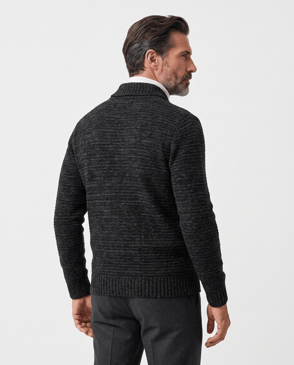 Back view of black textured cardigan worn with dark trousers
