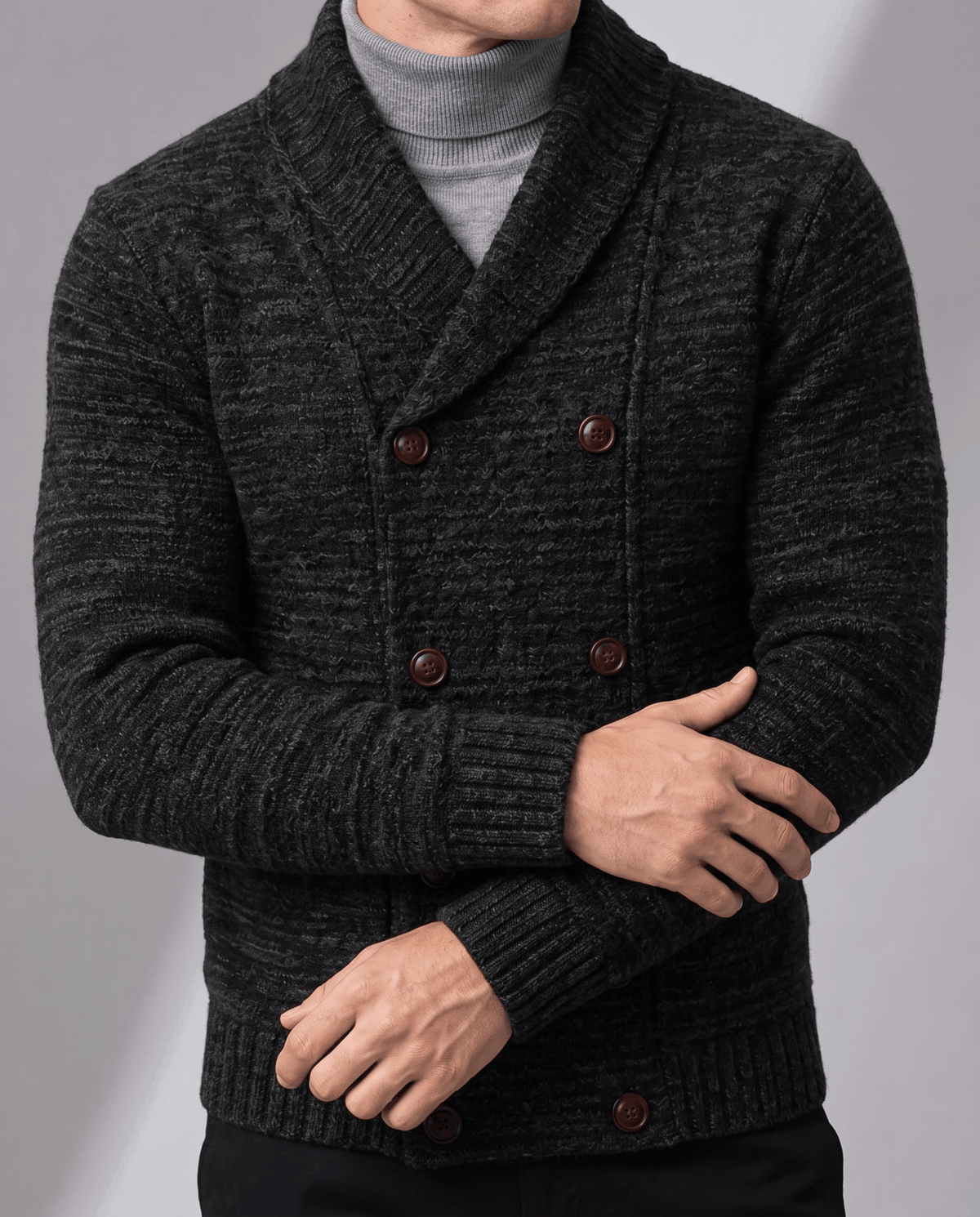 Black double-breasted cardigan with arm across showing textured knit and buttons