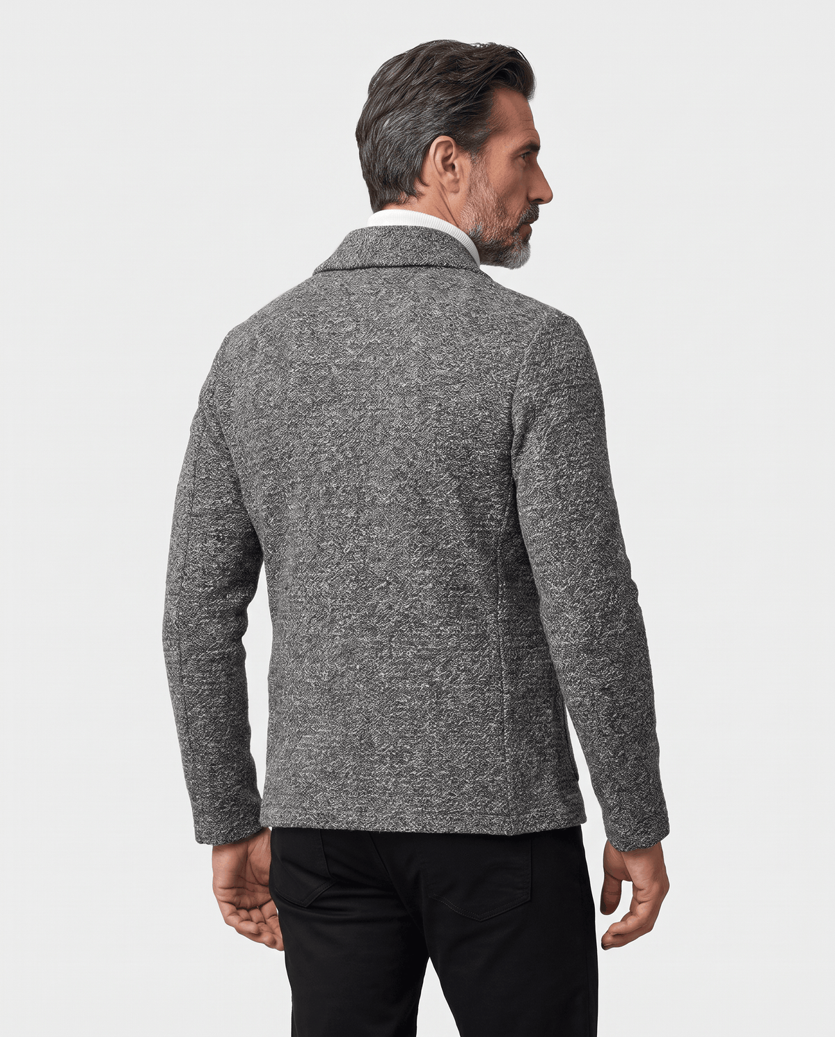 Back view of dark gray textured cardigan worn with dark trousers