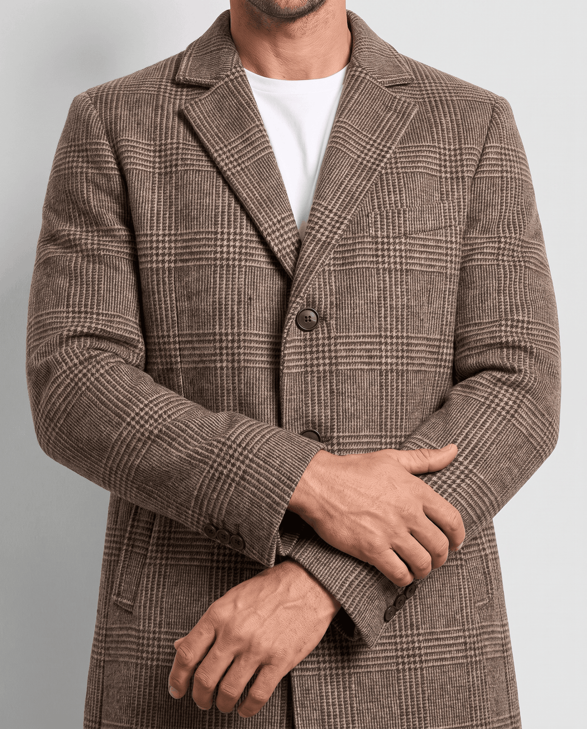 Close-up of the taupe overcoat's notch lapel and button front, worn over a white shirt