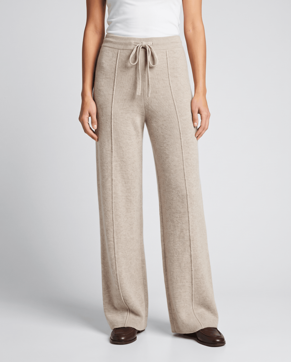 Beige oatmeal knit pants in front view with pintuck seams and loafers