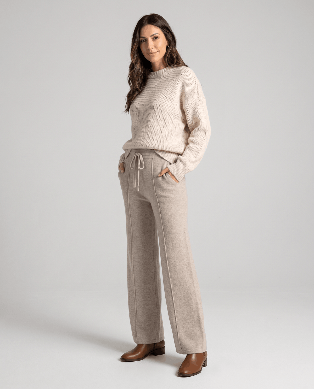 Model in cream sweater and beige wide-leg knit pants with brown boots
