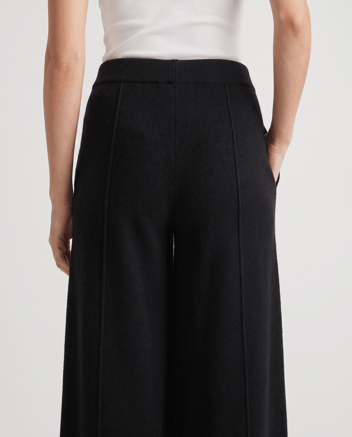 Back close-up of black wide-leg pants with pintuck seams